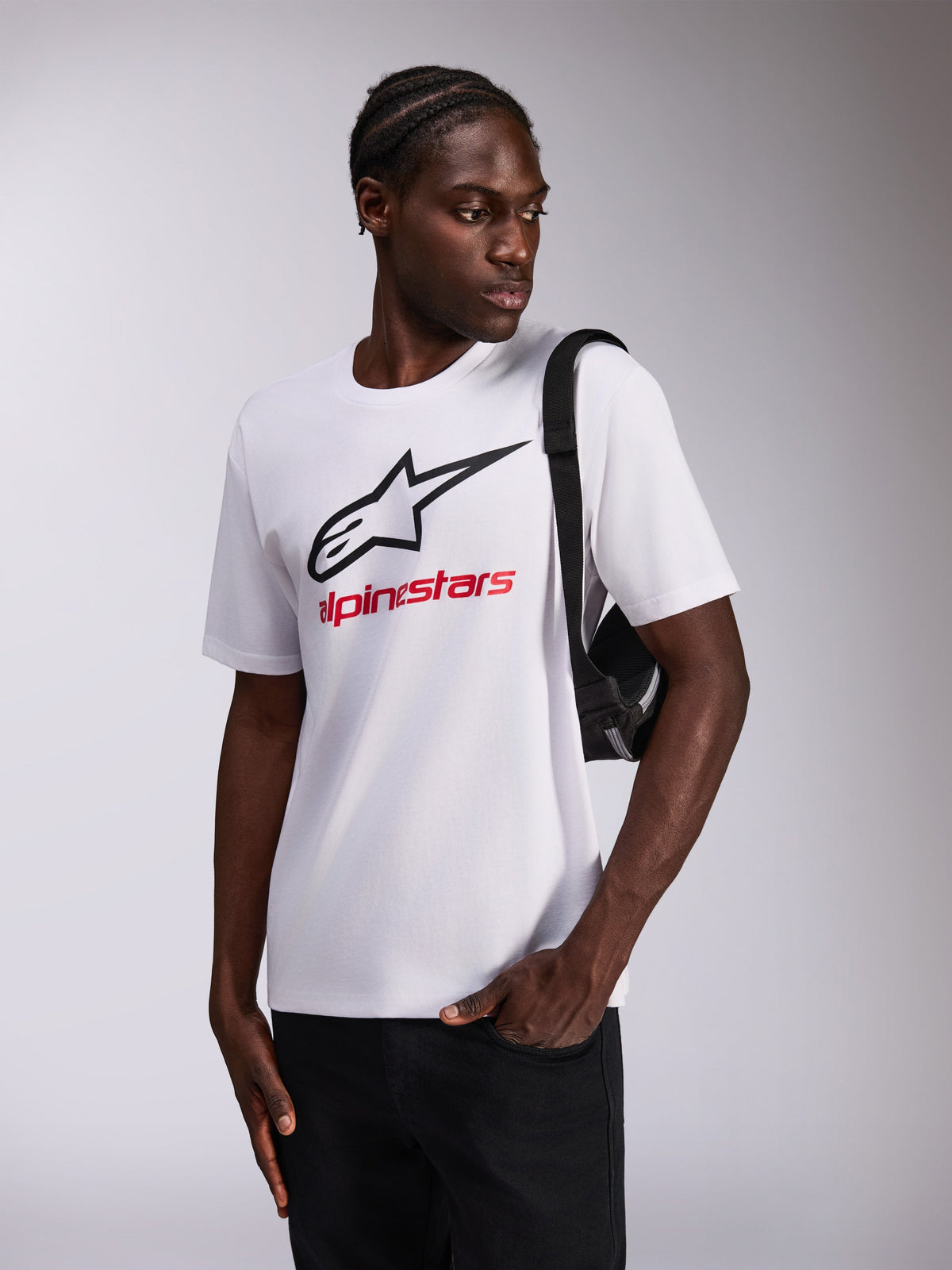 Alpinestars Always 2.0 CSF Tee, Short Sleeve T-Shirt, White, Black Star Logo and Red Alpinestars Text, worn by model with black crossbody bag, Casual Motorsport Sportswear
