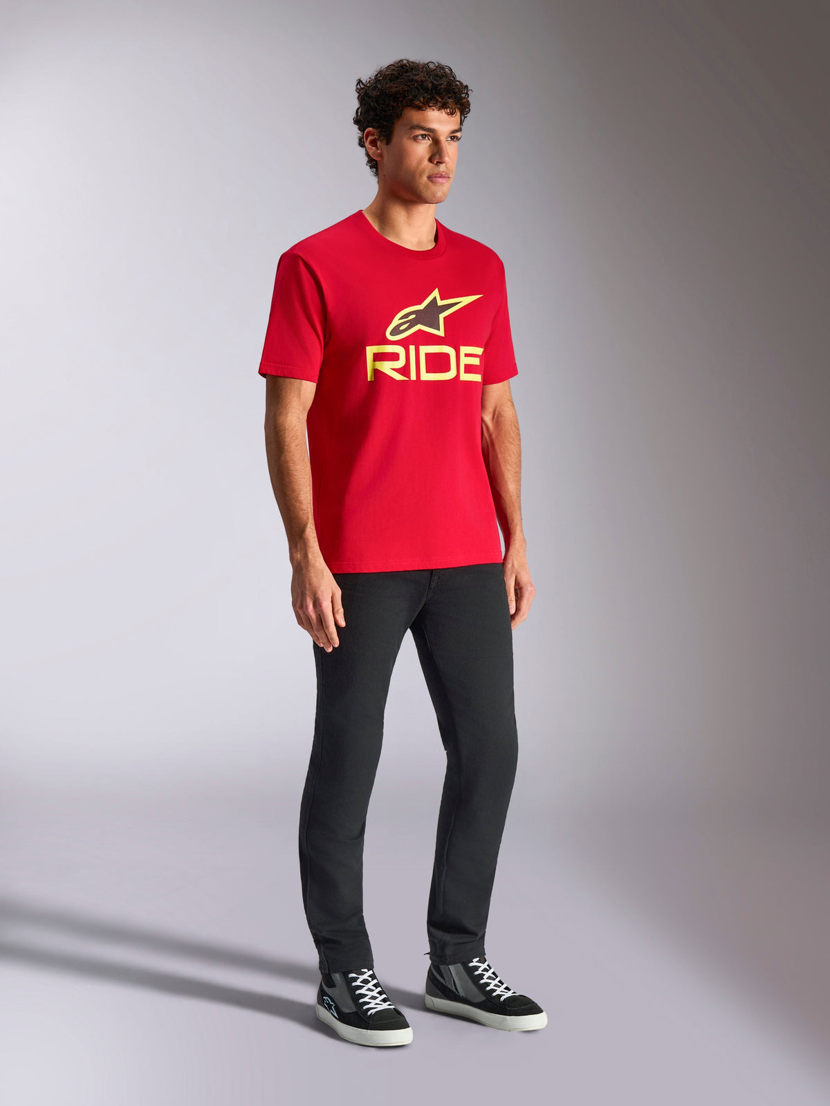 Alpinestars Ride 4.0 CSF Tee, Short Sleeve T-Shirt, Red, Yellow and Black Front Logo, worn with black pants and sneakers, Casual Motorsport Streetwear