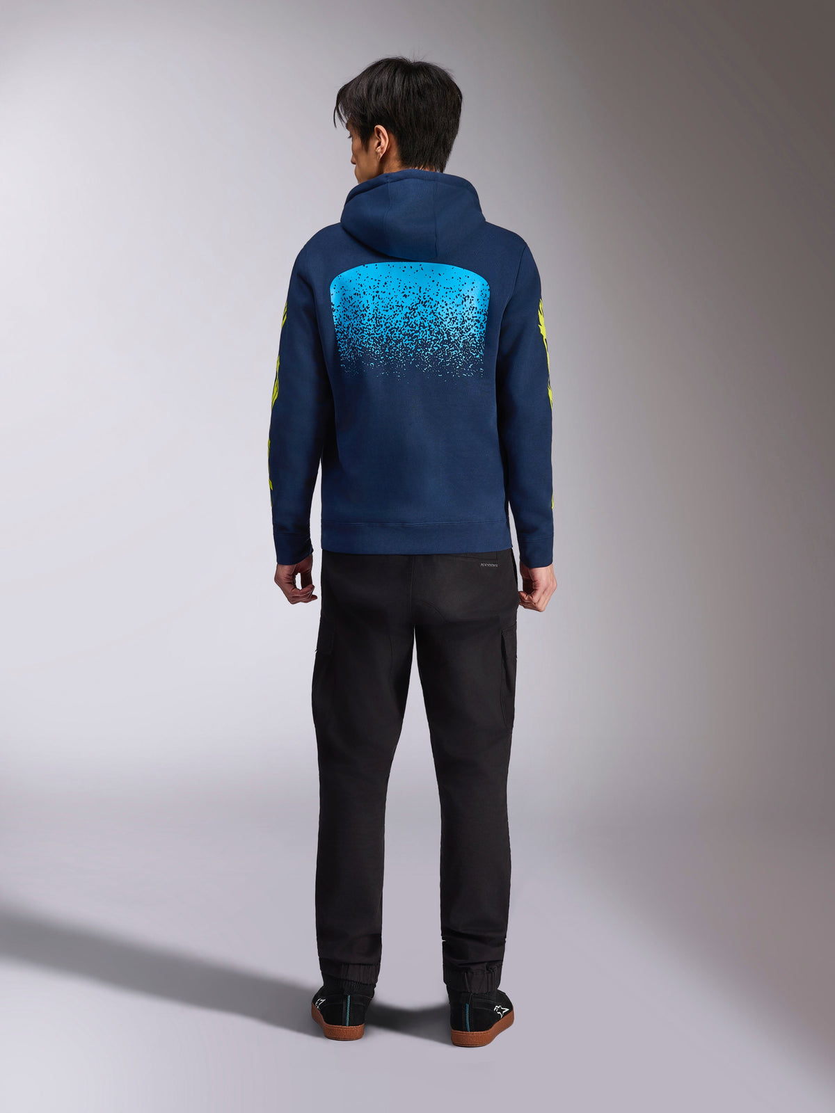 Alpinestars Obsessed Hoodie in Navy Blue, back view featuring a large cyan MX gradation graphic and yellow sleeve logos, casual motorsport-inspired pullover fleece.