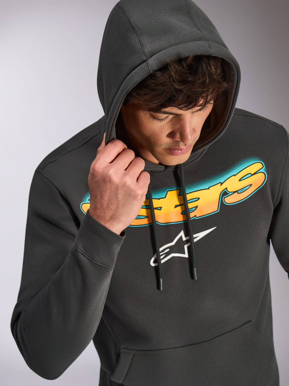 Alpinestars Ellipsoid Hoodie, Gunmetal gray, casual pullover hoodie featuring a cyan to orange gradient Astars wordmark and white logo, worn by model with hood up, motorsport-inspired streetwear