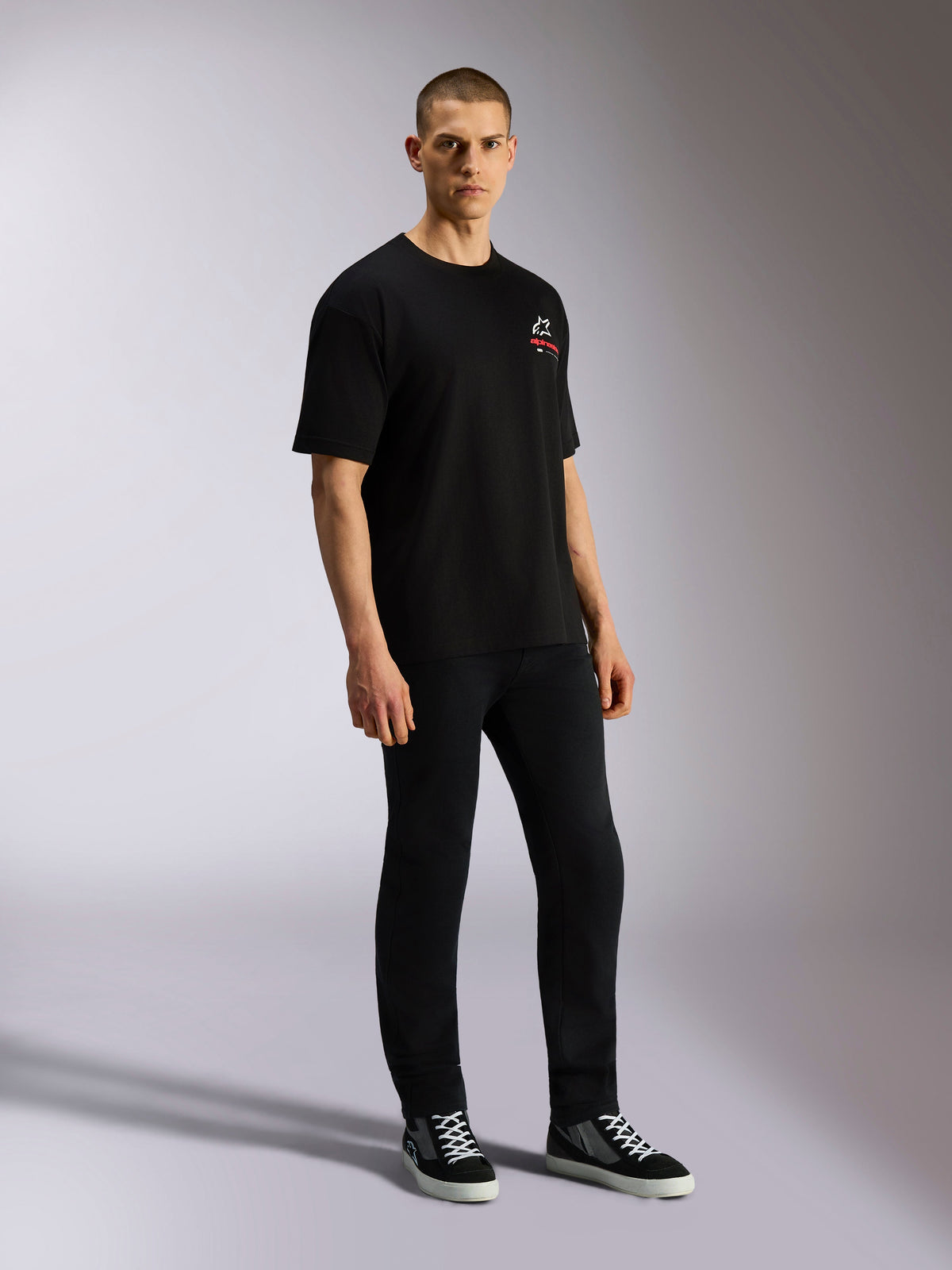 Alpinestars Overhang Oversized CSF Tee, Short Sleeve T-Shirt, Black, featuring a front white and red Astars logo, worn by a model with black pants and sneakers, oversized casual streetwear design