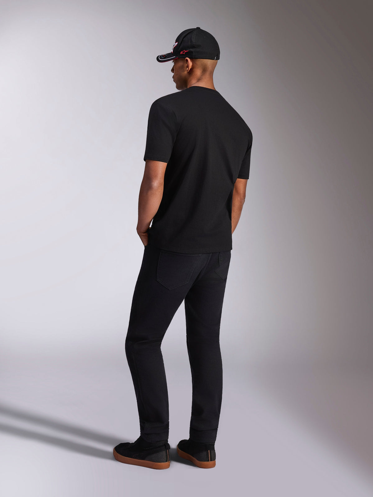 Alpinestars Plate CSF Tee, Short Sleeve T-Shirt, Black, back view on model wearing black pants and a baseball cap, casual motorsport streetwear