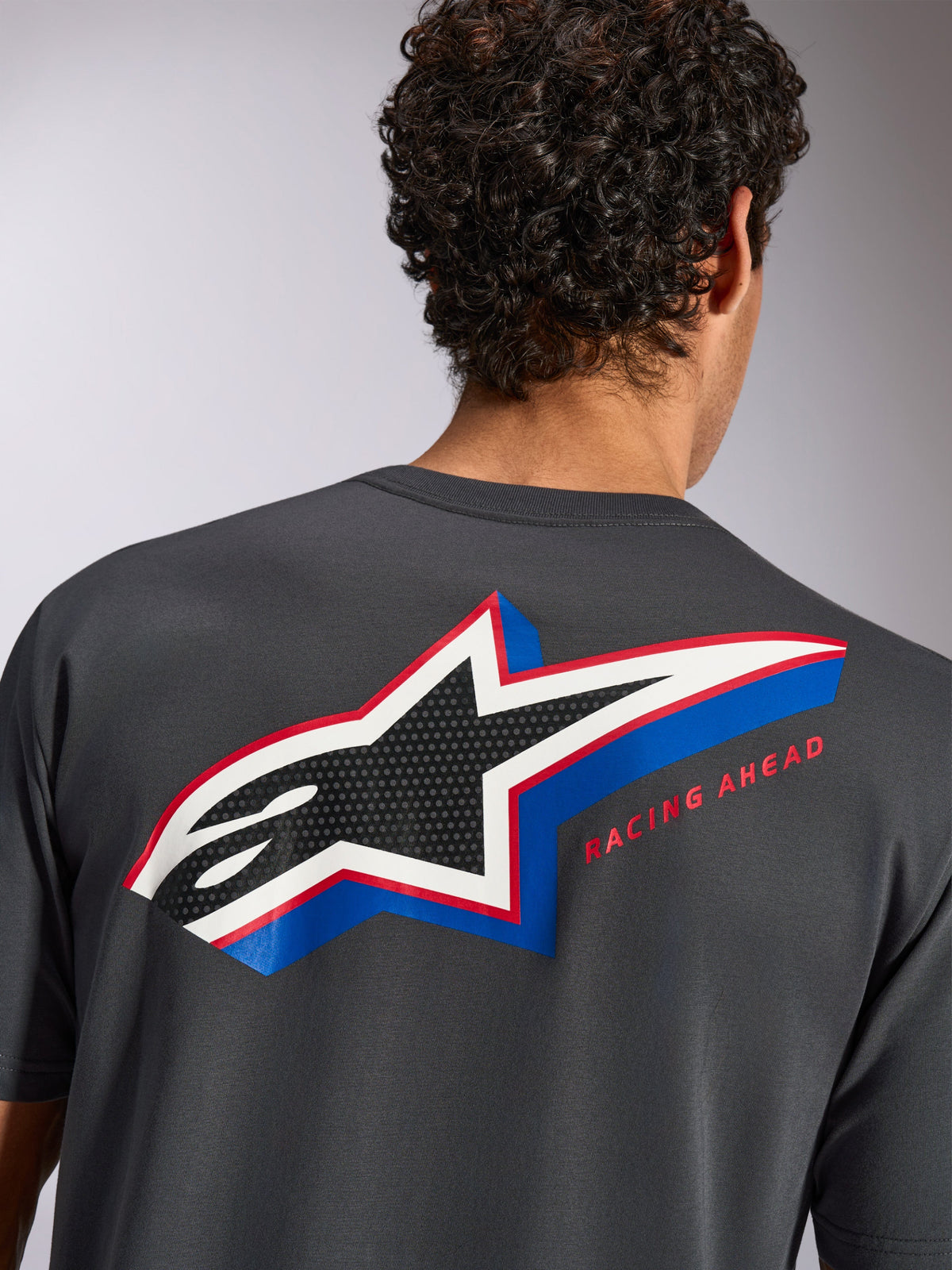 Alpinestars Angler CSF Tee, Short Sleeve T-Shirt, Charcoal, Back view on model featuring large multi-color Alpinestars star logo with perforated fill and 'RACING AHEAD' text, Casual Motorsport Streetwear