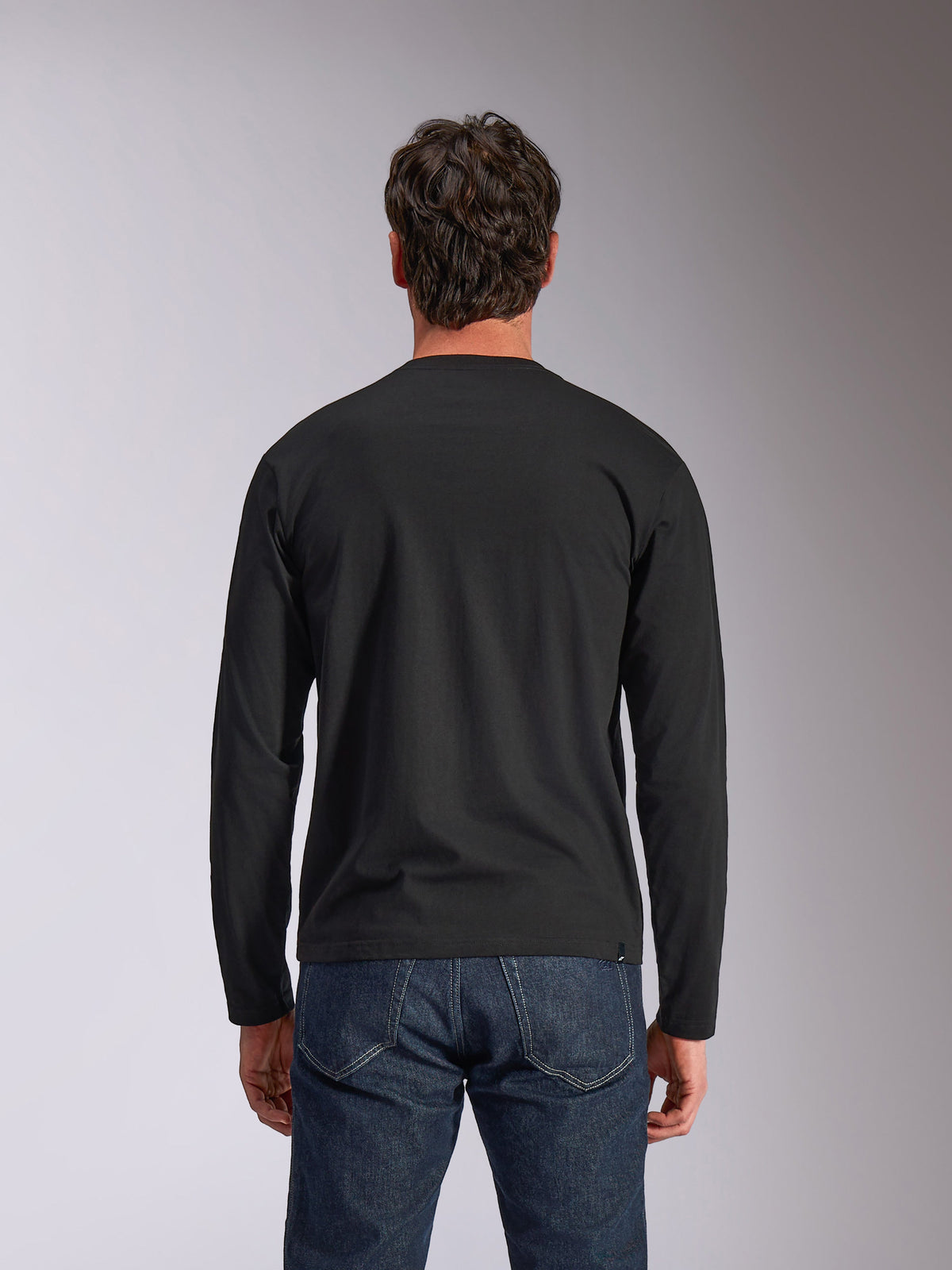 Alpinestars Trackside CSF Tee, Long Sleeve T-Shirt, Black, Back View, worn with dark blue denim jeans, casual motorsport-inspired streetwear