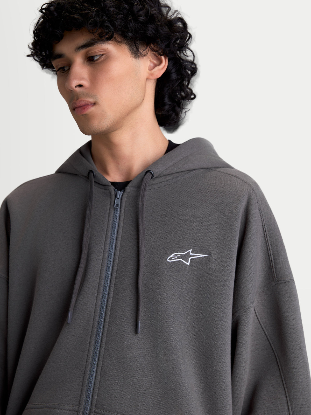 Alpinestars Entity Oversized Hoodie, Sportswear Zip Fleece for Men and Women, Charcoal Gray, 80% Cotton and 20% Recycled Polyester, featuring a Vislon front zipper, self-lined hood with flat drawcords, and a white Astars logo embroidered on the chest.