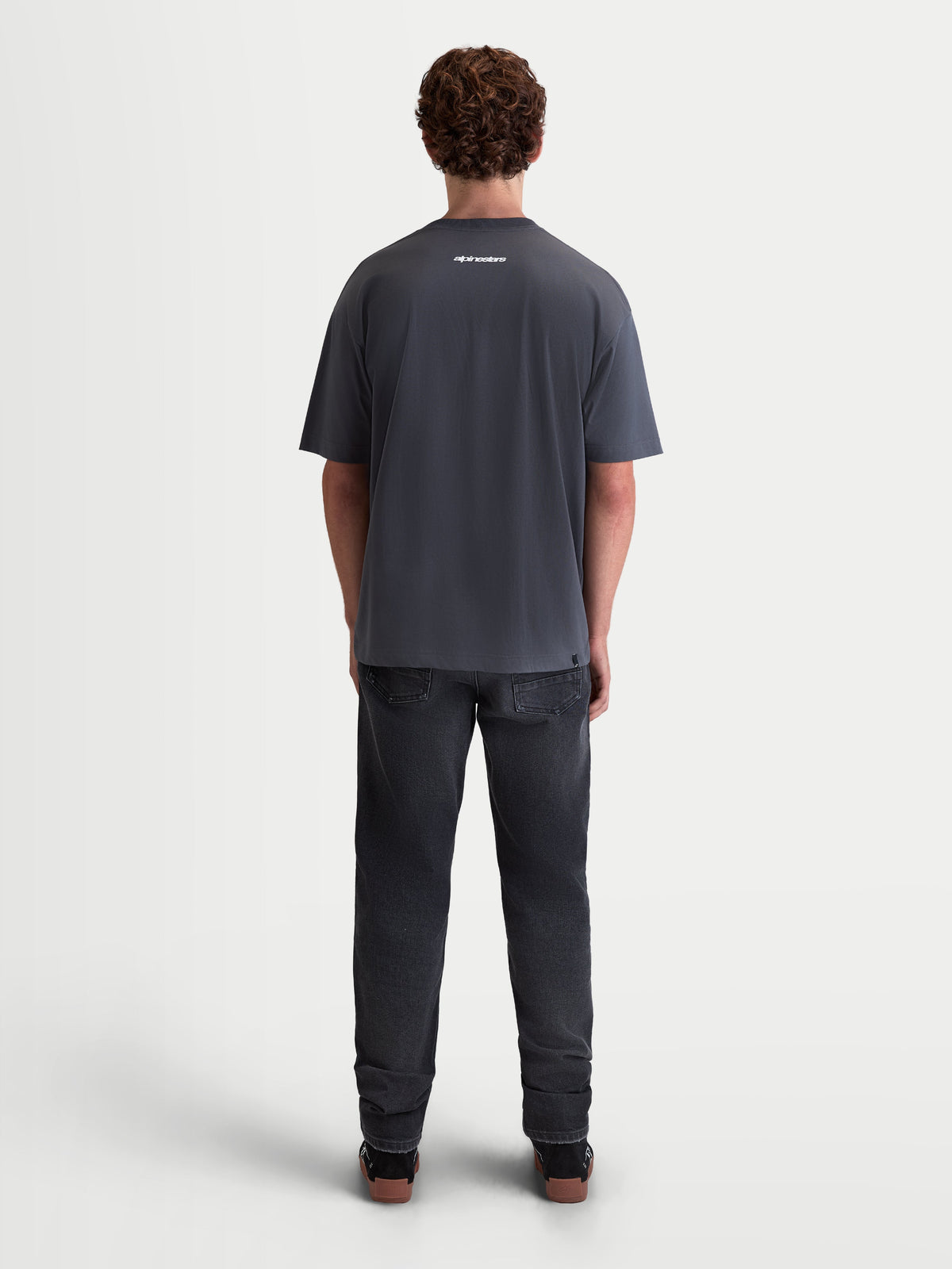 Alpinestars Prelude Oversized CSF Tee, Men's Casual Short Sleeve Sportswear T-shirt, Charcoal Gray, featuring a small white logo on the upper back, relaxed oversized fit, soft cotton-poly blend, back view on model.