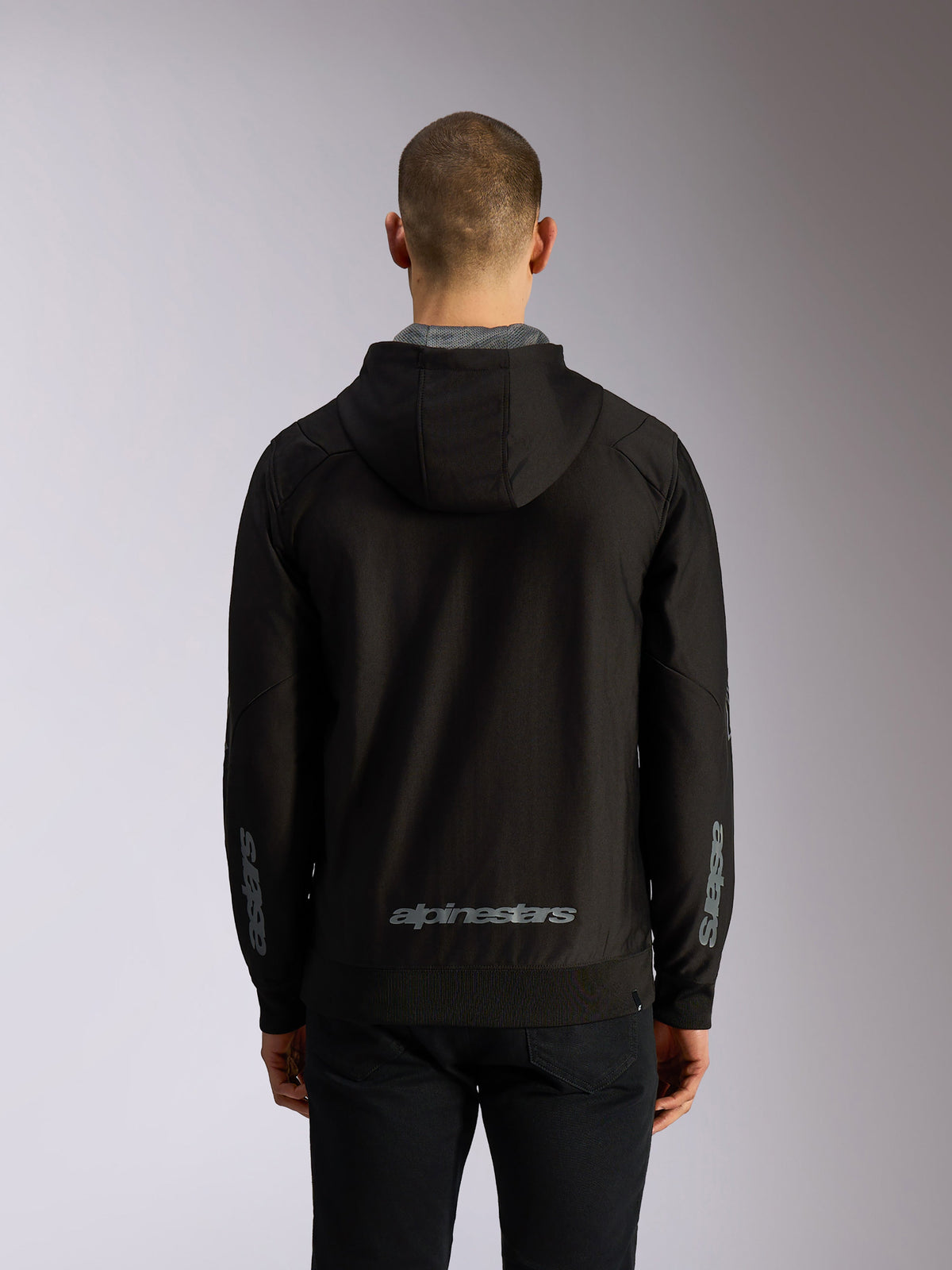 Alpinestars Sessions V3 Hoodie, back view, black zip-up hoodie with grey Alpinestars wordmark on the lower back, Astars branding on sleeves, ribbed hem and cuffs, casual motorsport streetwear