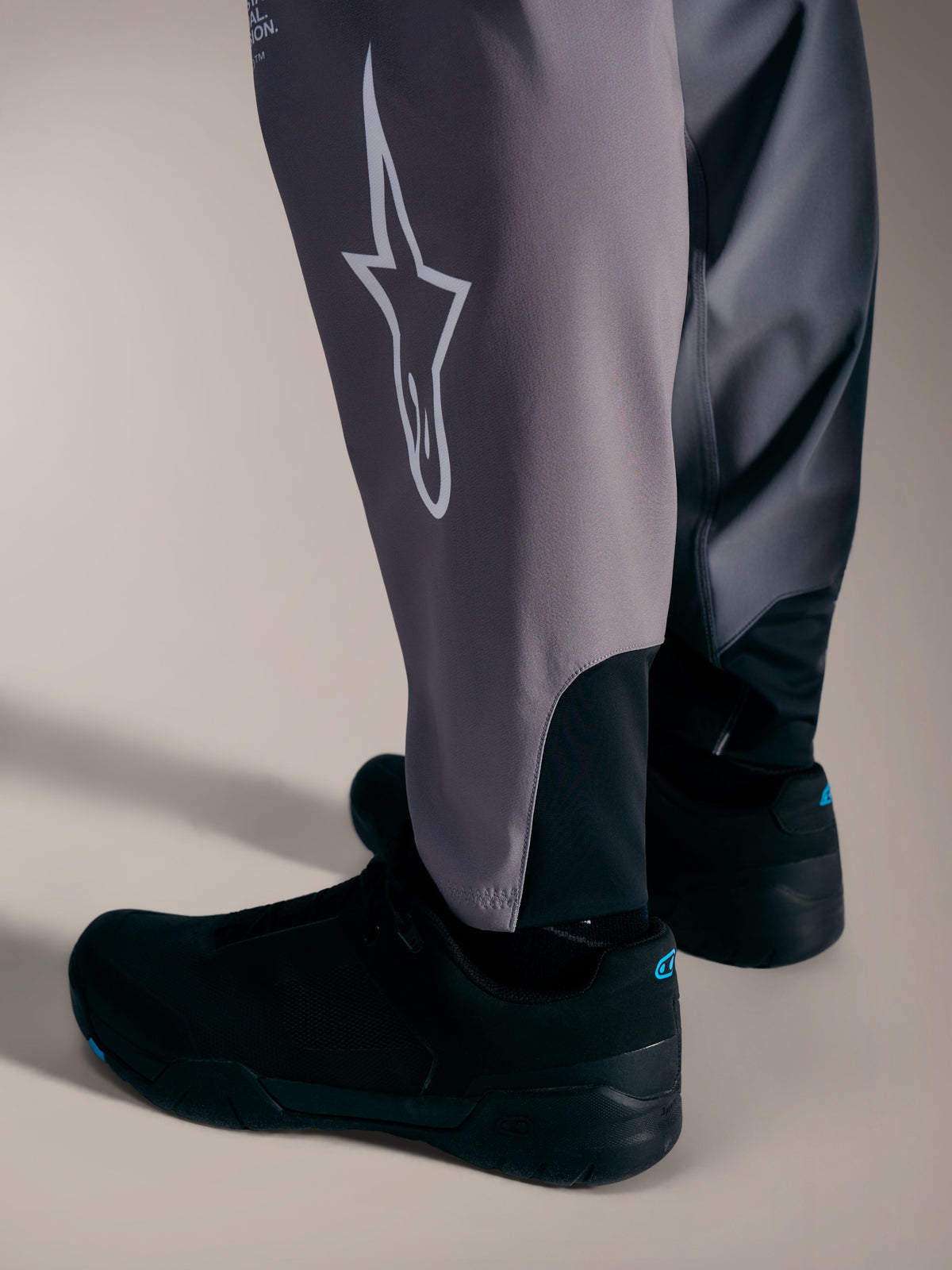 A-Supra Elite Pants in gray, detailing the white Astars logo and stretch cuffs designed for performance MTB racing.