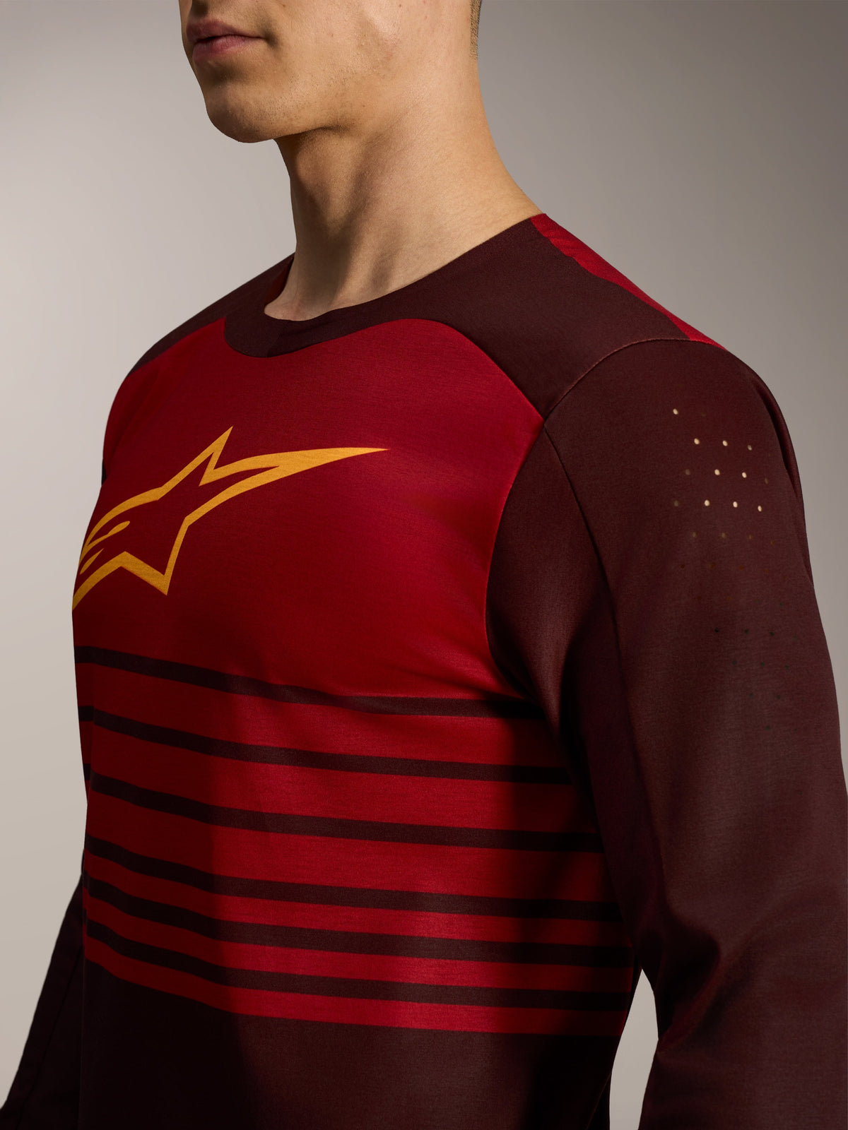 A-Dura Elite Jersey 2.0 in Bordeaux red with long sleeves, featuring a yellow chest logo and laser-cut bicep perforations.