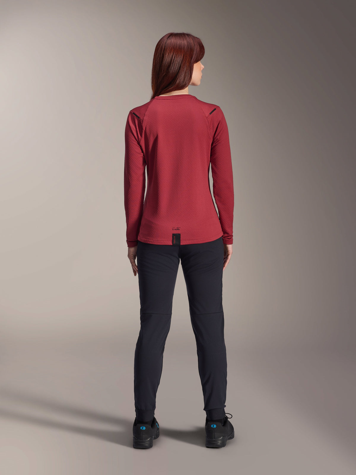 Alpinestars Stella A-Dura Thermal Pants, Women's Mountain Bike Pants, Black, worn with a burgundy long-sleeved thermal jersey, back view showing the technical fit and construction for cold-weather cycling.