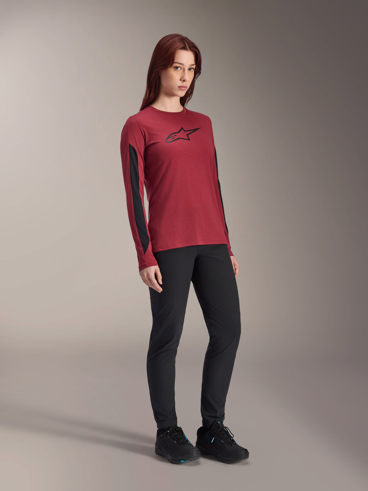 Alpinestars Women Stella A-Dura Dri Astar Long Sleeve Jersey, Burgundy red with black chest logo and black mesh panels on the sleeves, worn with black technical pants and black riding shoes, high-performance mountain bike apparel for women