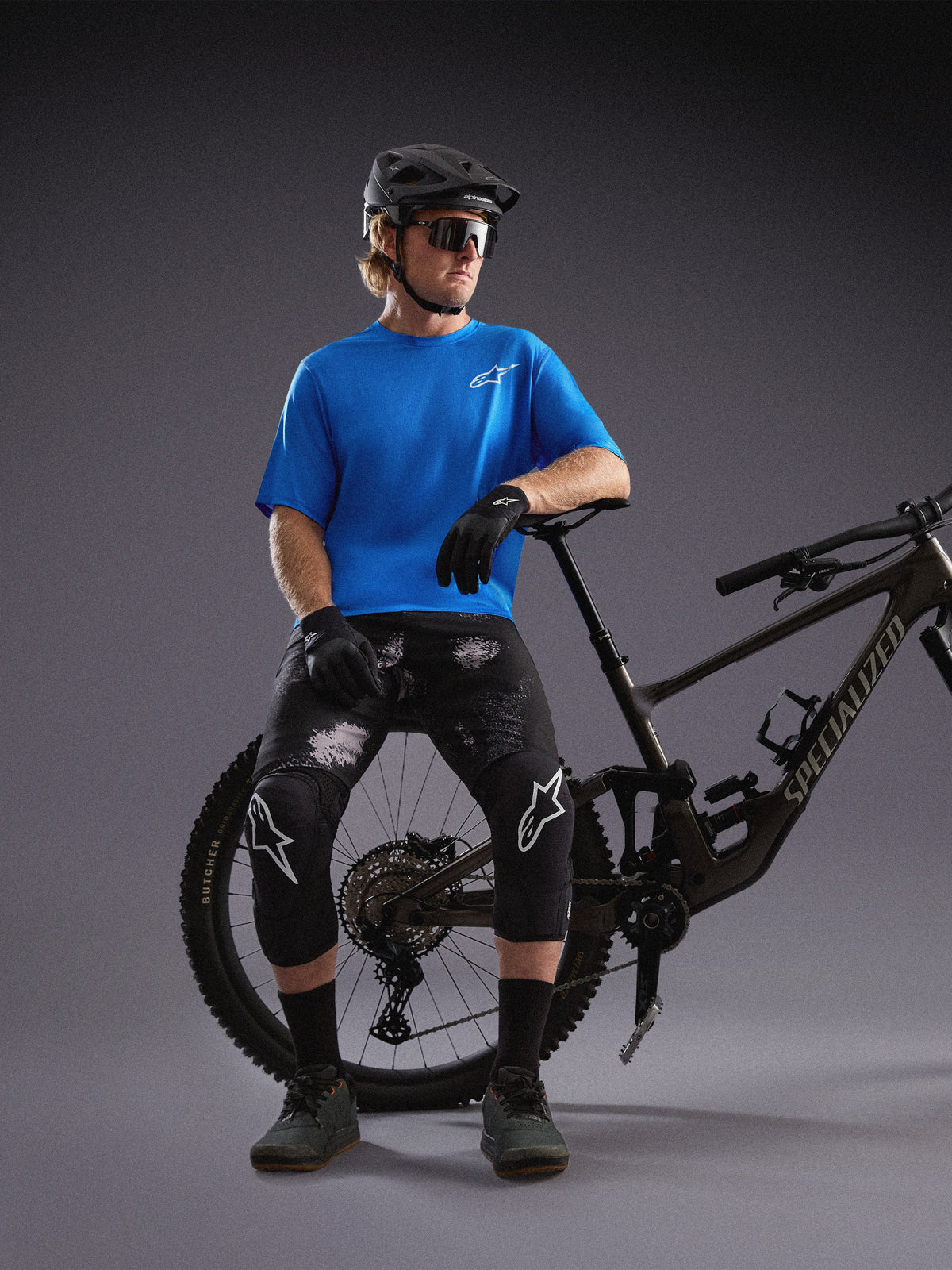 Alpinestars A-Dura Air SS Jersey and Black Camo Ride Shorts worn by a cyclist with a mountain bike in a studio.
