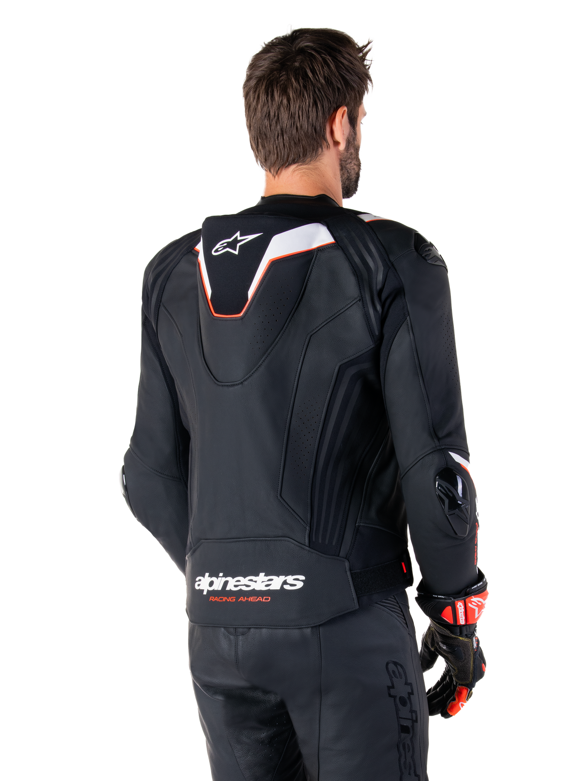 Alpinestars Missile V3 Ignition Leather Jacket, Rear View, Black with White and Red accents, featuring a slim sport Aero-hump and Alpinestars branding, worn with matching leather pants and racing gloves
