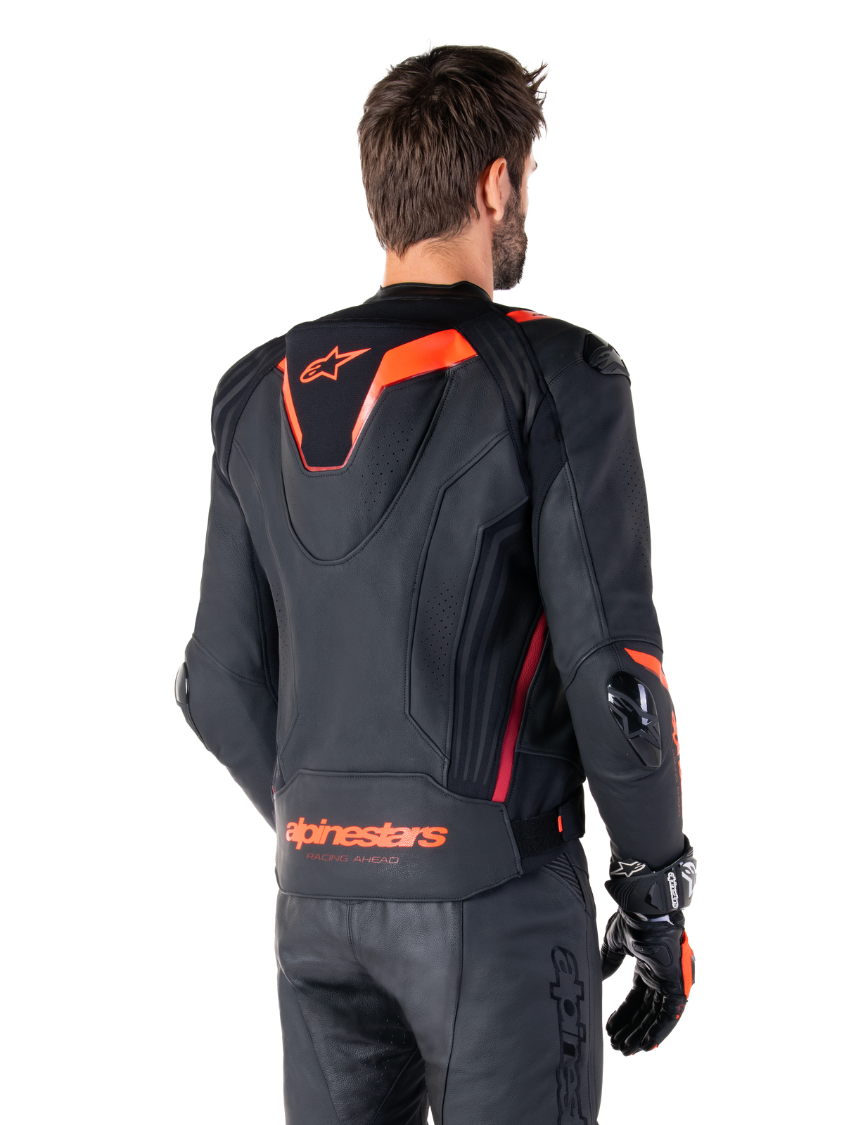 Alpinestars Missile V3 Ignition Leather Jacket, Men's Racing Sport Jacket, Black with Red Fluo accents, back view featuring the slim aerodynamic sport hump and Alpinestars branding on the lower back, worn with black leather pants and racing gloves, sleek professional motorsport design