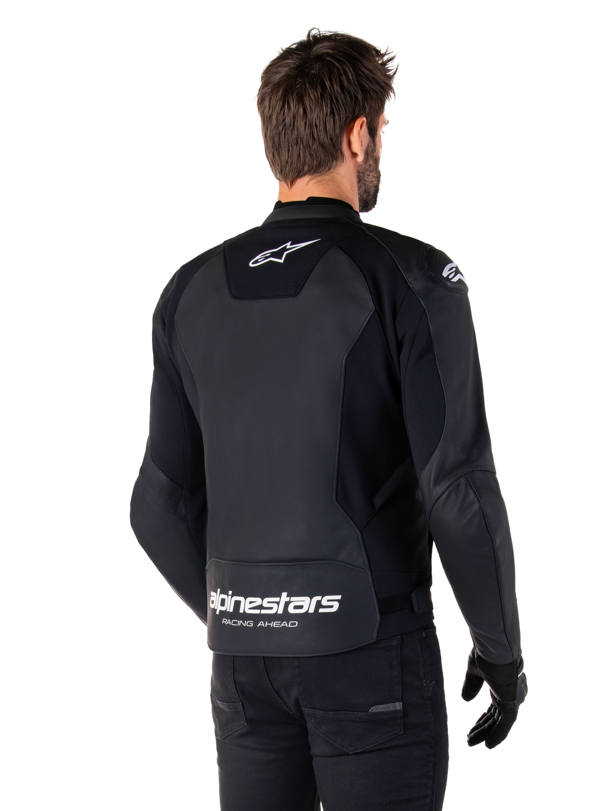 Alpinestars Faster V3 Leather Jacket, Black and White, rear view on a rider, featuring white star logo on the upper back and large Alpinestars branding with "Racing Ahead" on the lower tail, elongated rear for riding coverage, premium sport leather construction