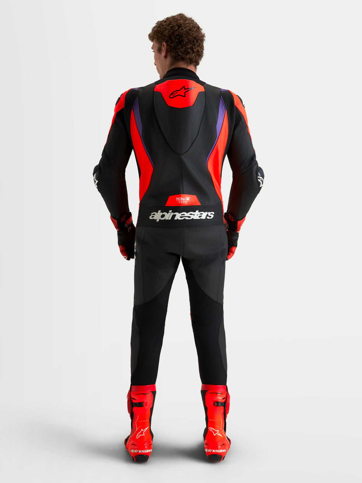 Alpinestars Missile V3 Leather Suit 1 Piece, men's racing leather suit, Black, Red, and Purple, featuring an aerodynamic speed hump, DFS armor, and Tech-Air ready design, rear view on model