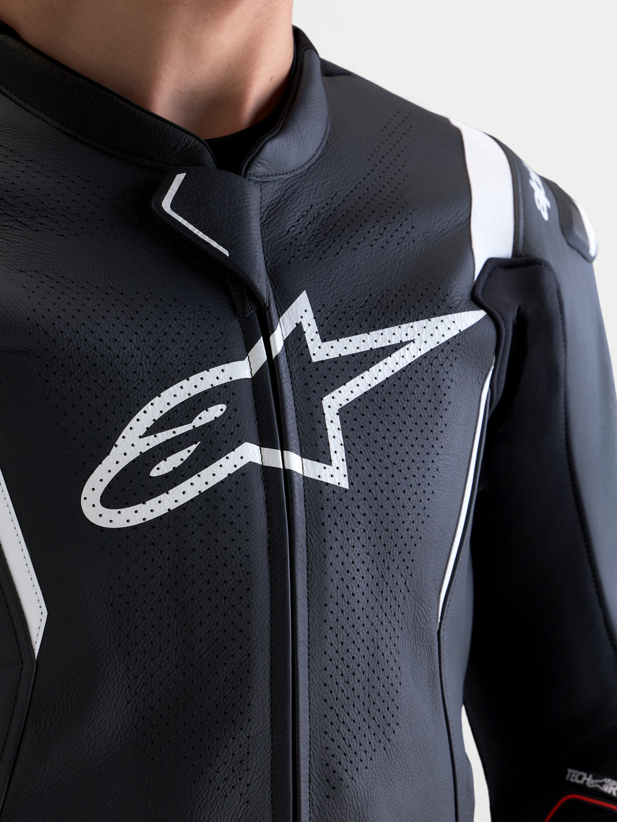 Alpinestars Missile V3 Leather Suit - 2 Piece, Black and White, close-up of perforated leather chest panel with white Astar logo, MotoGP-inspired closure tab, and shoulder protection