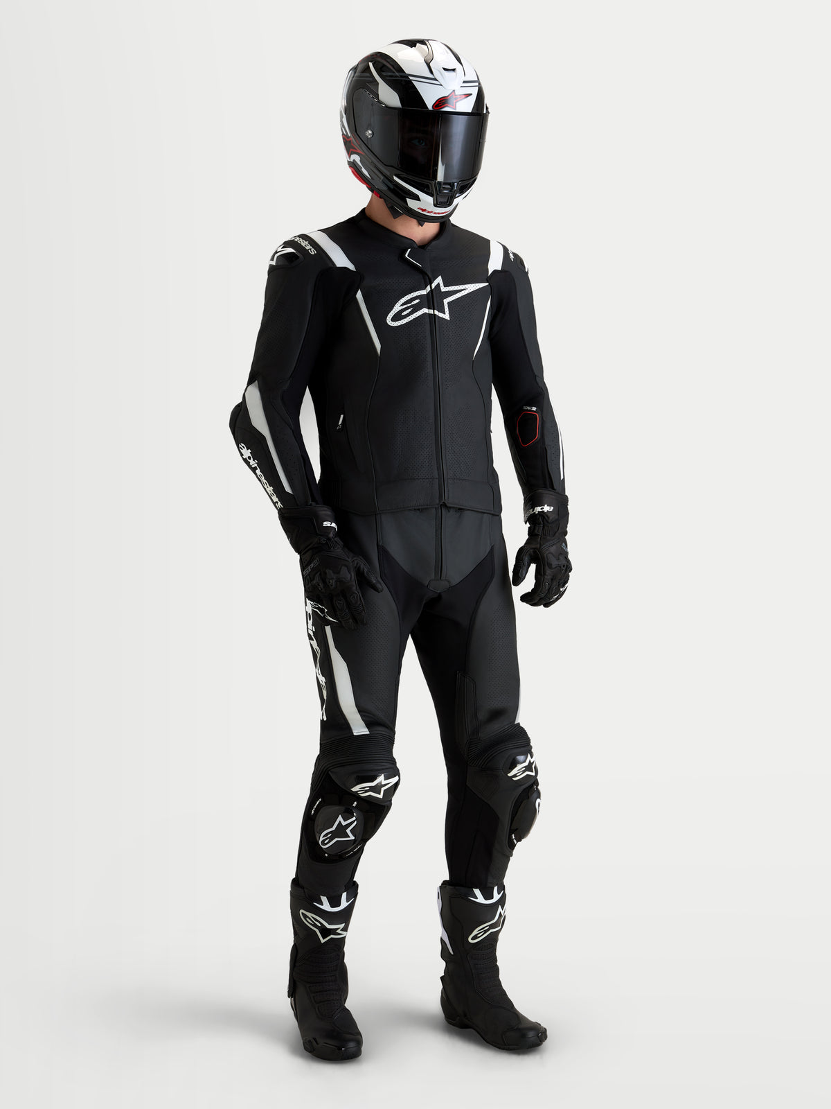 Alpinestars Missile V3 Leather Suit 2 Pc, men's black and white two-piece motorcycle racing suit, AAA-rated leather with DFS shoulder armor and ventilated design, worn by a rider wearing a matching helmet and boots