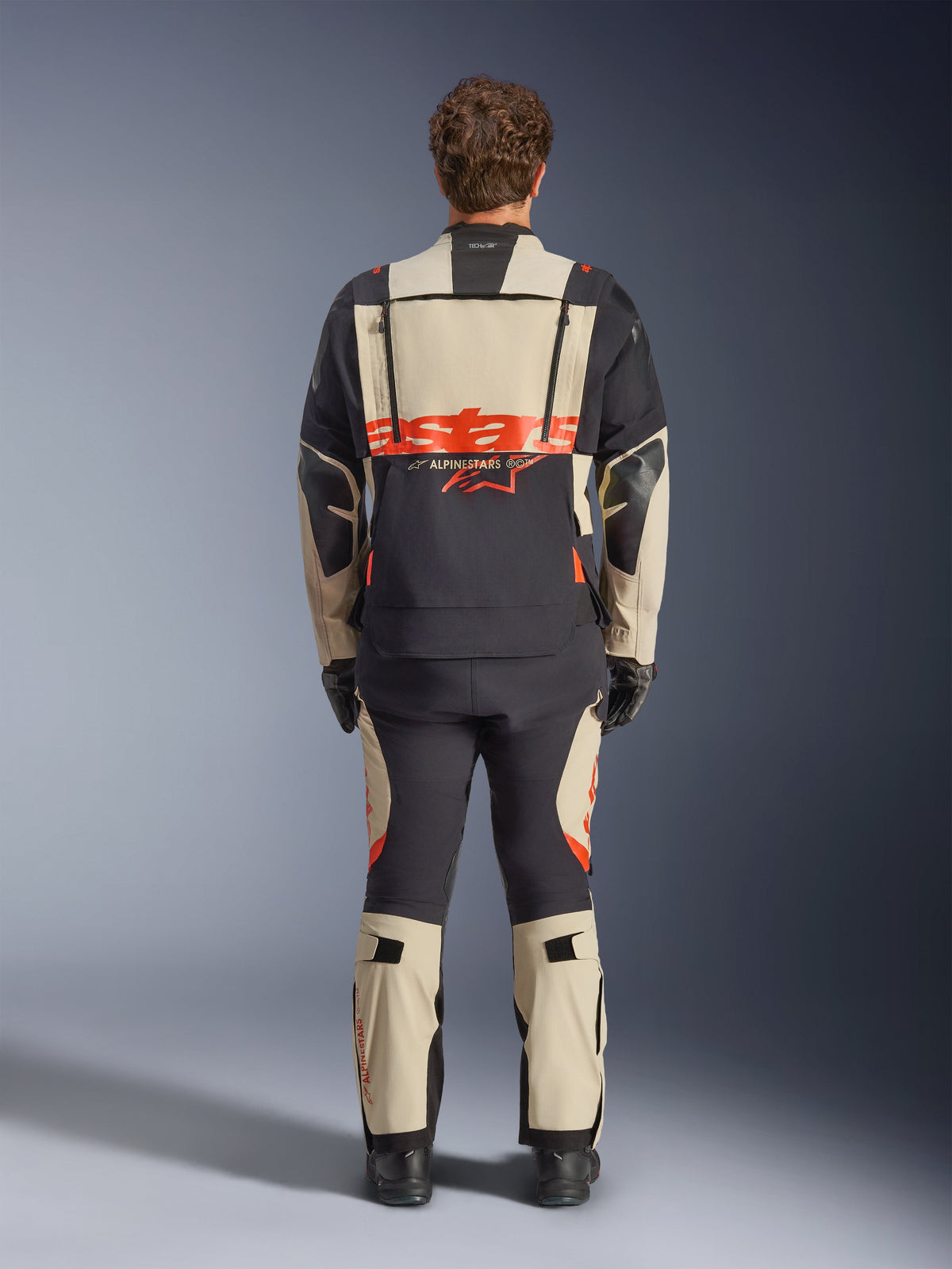 Alpinestars Harok Pro Drystar® XF Laminated Jacket, men's adventure motorcycle jacket in Mastic Black, rear view showing large back branding and modular ventilation zippers, worn with matching adventure pants.