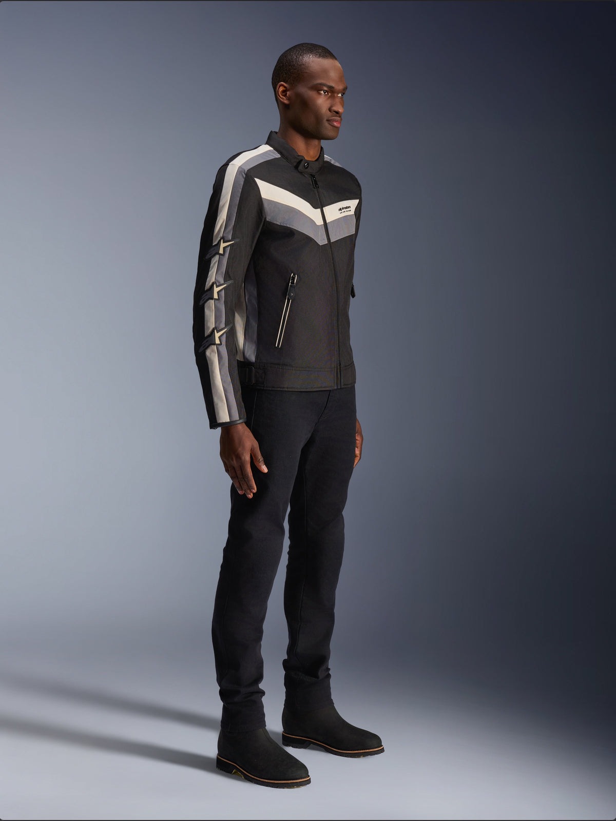 Alpinestars T-Dyno WR Jacket, textile motorcycle jacket, black with dark gray and ecru chevron accents, vintage-inspired biker fit, worn with black pants and boots for a complete road-riding look