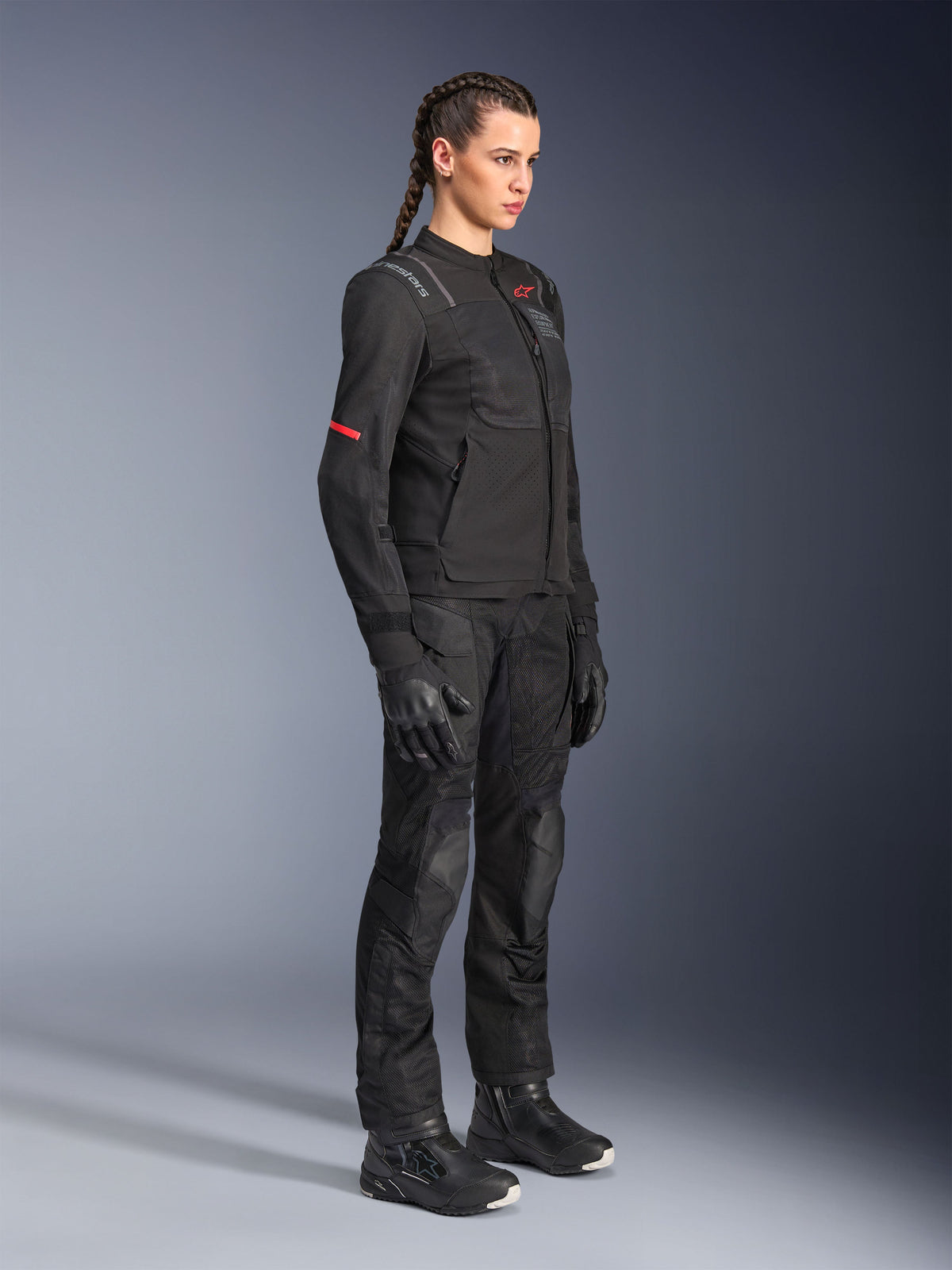 Female rider wearing Alpinestars Stella Andes Air Drystar® Pants in Black, textile adventure pants with mesh ventilation panels, styled with a matching Stella jacket, gloves, and boots for a complete motorcycle touring outfit.