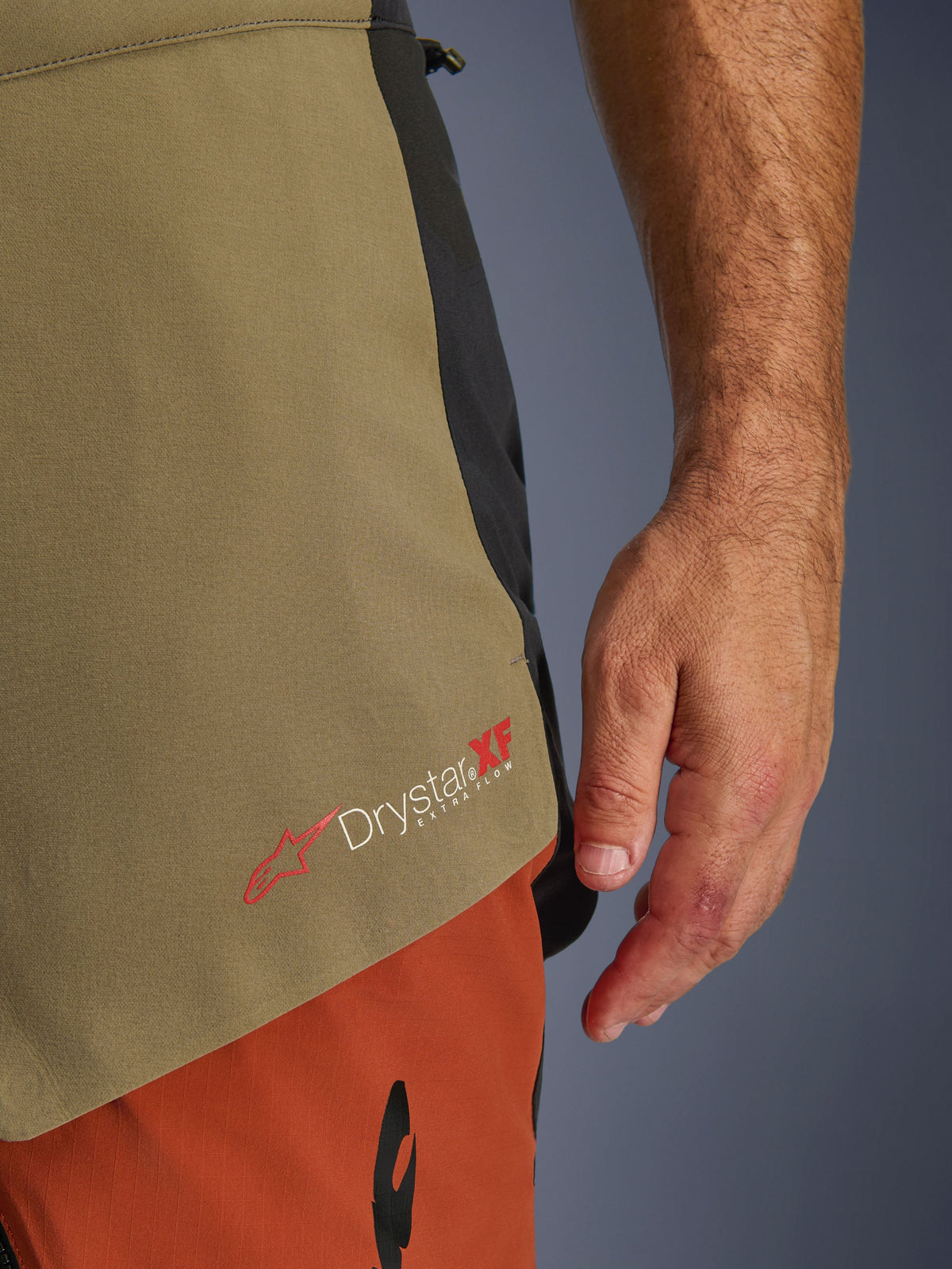 Alpinestars Halo Pro Drystar® XF Laminated Pants, Walnut Rust Black, close-up detail of the Drystar XF Extra Flow branding, showing the olive green and rust orange textile panels and technical construction.