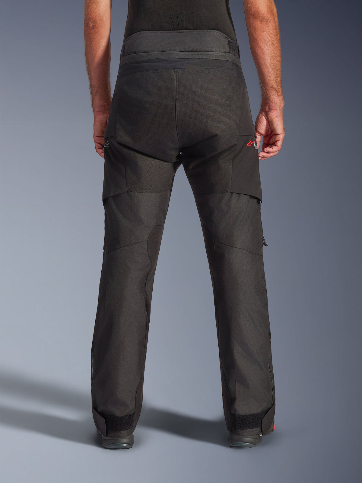 Alpinestars Andes V4 Drystar® Pants - Long, Black adventure motorcycle pants, rear view, featuring reinforced seat panels, red Astar logo, and adjustable ankle straps for a secure fit.