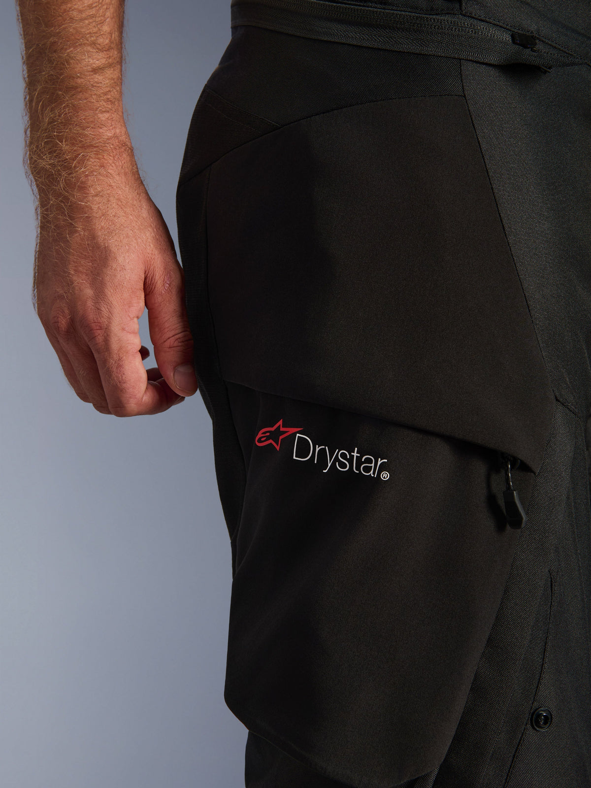 Alpinestars Andes V4 Drystar® Pants, Black, close-up of the thigh area showing the Drystar® logo on a cargo pocket, technical textile material with reinforced panels, waterproof adventure motorcycle riding pants