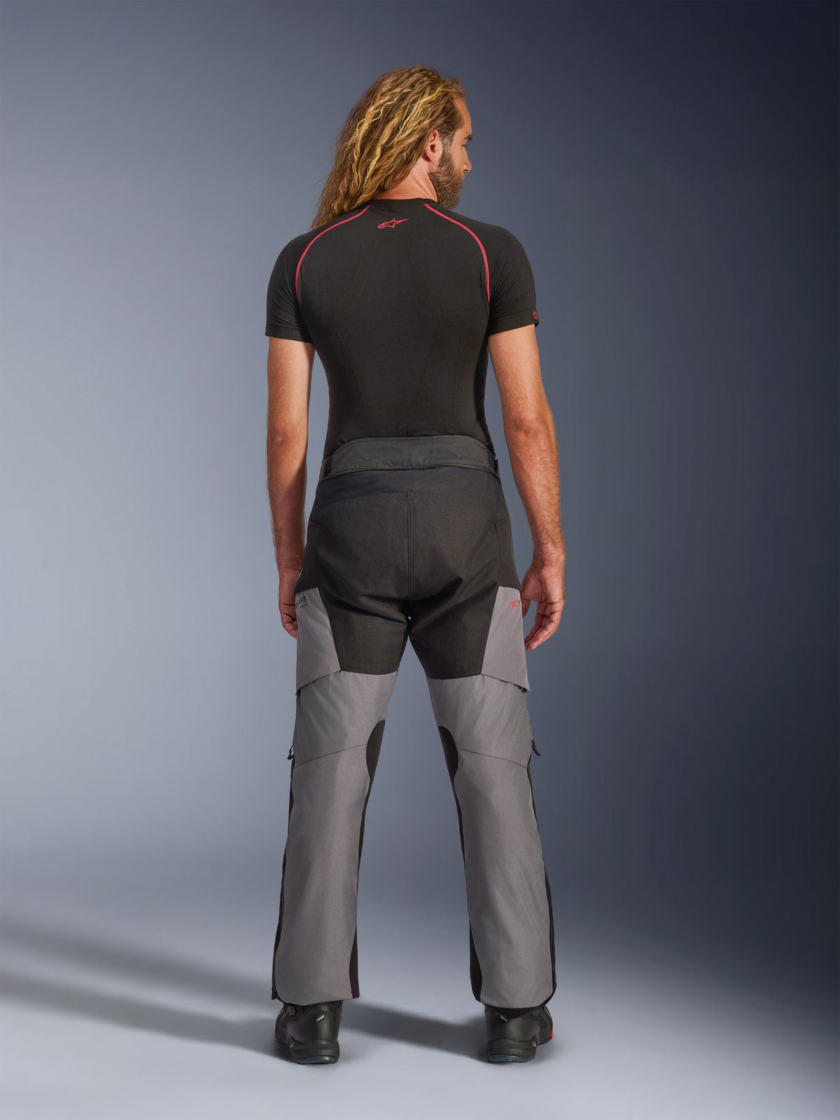 Alpinestars Andes V4 Drystar® Pants, Motorcycle Adventure Pants, Black and Dark Gray, rear view worn by a model, featuring reinforced textile panels on the seat and legs, designed for all-weather touring and commuting.