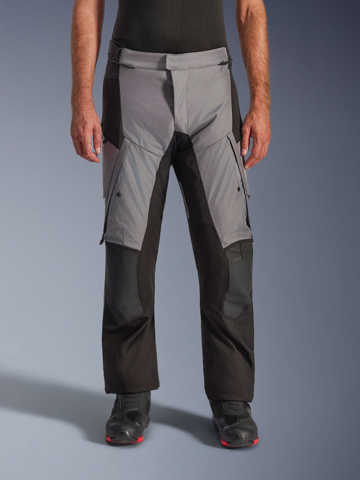 Alpinestars Andes V4 Drystar® Pants, Motorcycle Adventure Touring Pants, Gray and Black, front view worn by a model with black riding boots, featuring reinforced knee patches and thigh cargo pockets, waterproof breathable textile construction for all-weather riding
