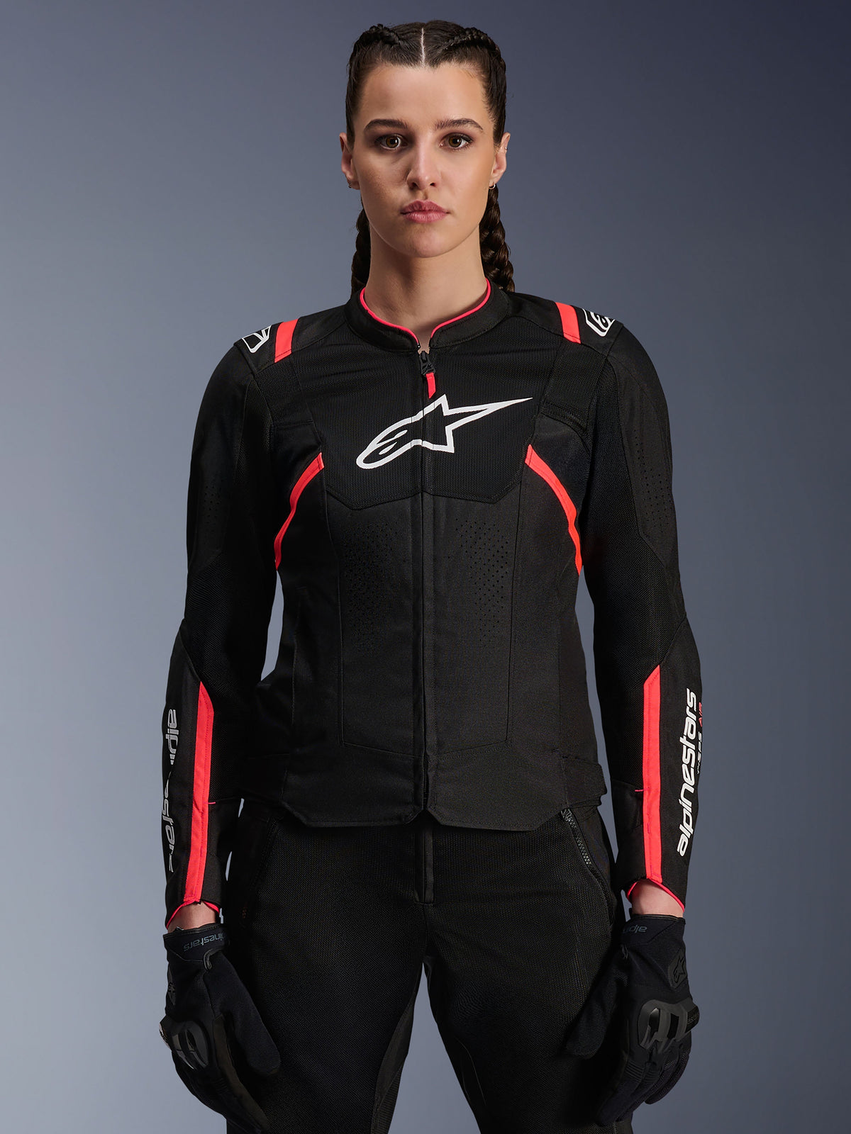 Alpinestars Woman Stella T-Sps Air V2 Jacket, Black and Diva Pink, textile motorcycle jacket featuring breathable mesh panels and pink accents, white Alpinestars logo on chest, worn by a female model with black riding pants and gloves.