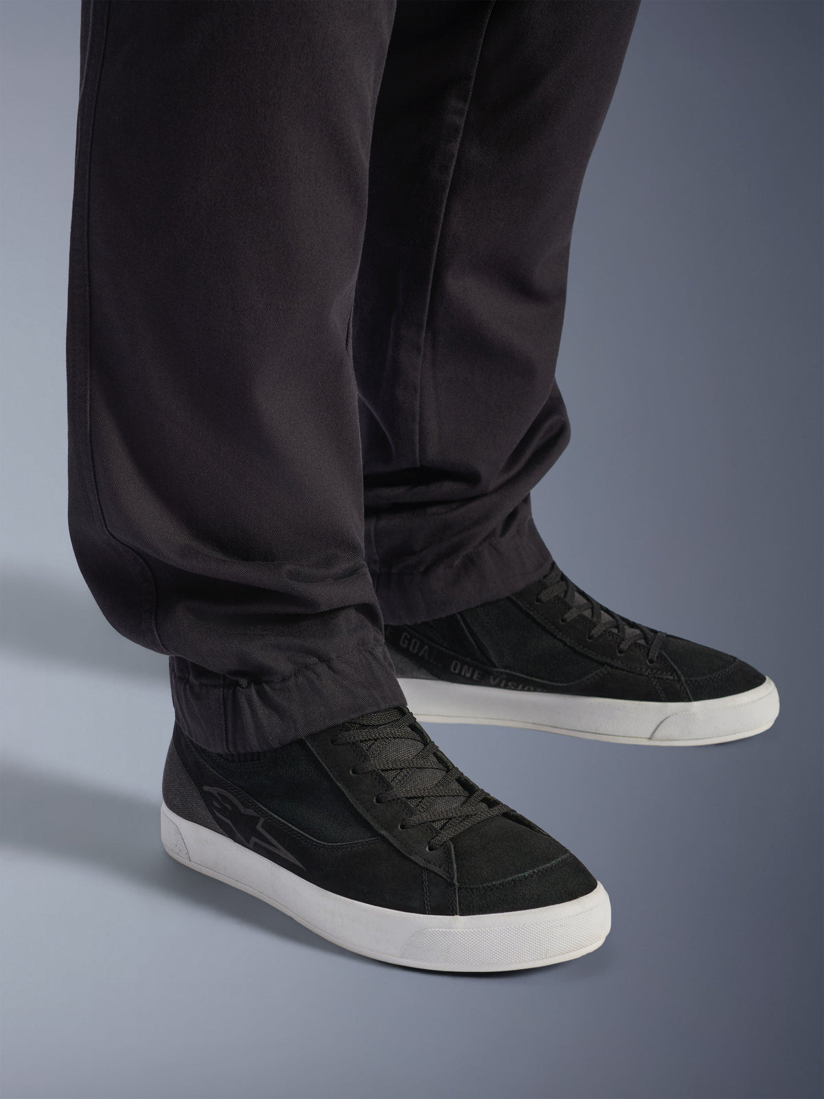 Alpinestars Flex-AST Cargo Pants - Short, Urban Motorcycle Pants, Black, featuring tapered legs with elasticated hems, paired with black Alpinestars sneakers, contemporary urban riding style