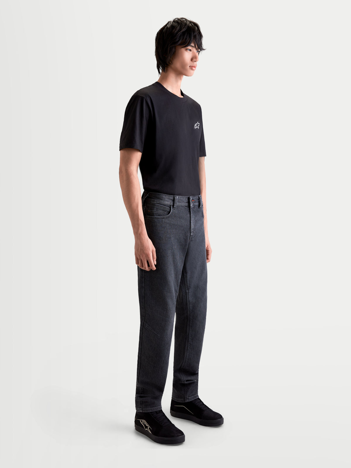 Alpinestars Flex-AST 7 Denim Pants Short, men's urban motorcycle riding jeans in faded black, side profile view worn by a model with a matching black t-shirt, AA certified technical denim with protective features.
