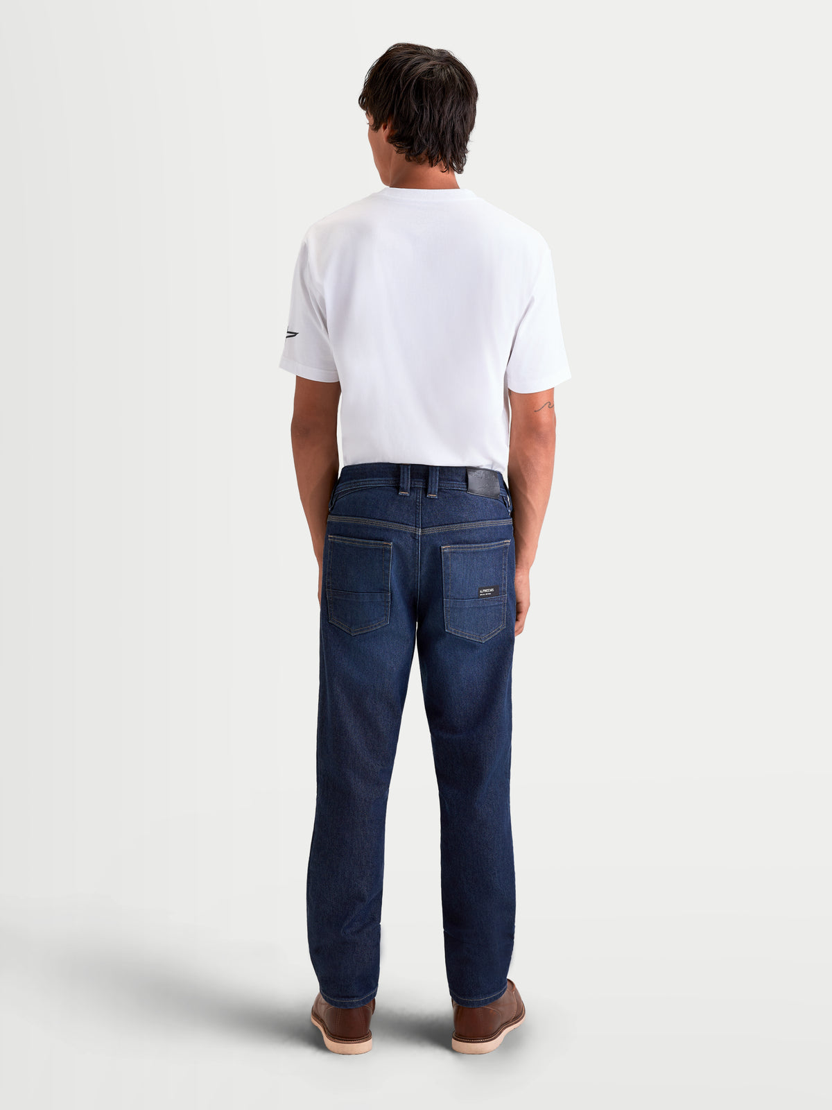 Alpinestars Flex-AST 7 Denim Pants Short, men's urban motorcycle riding jeans in dark blue, rear view on a model wearing a white t-shirt, showing single-layer technical denim construction, leather back patch, and back pockets.