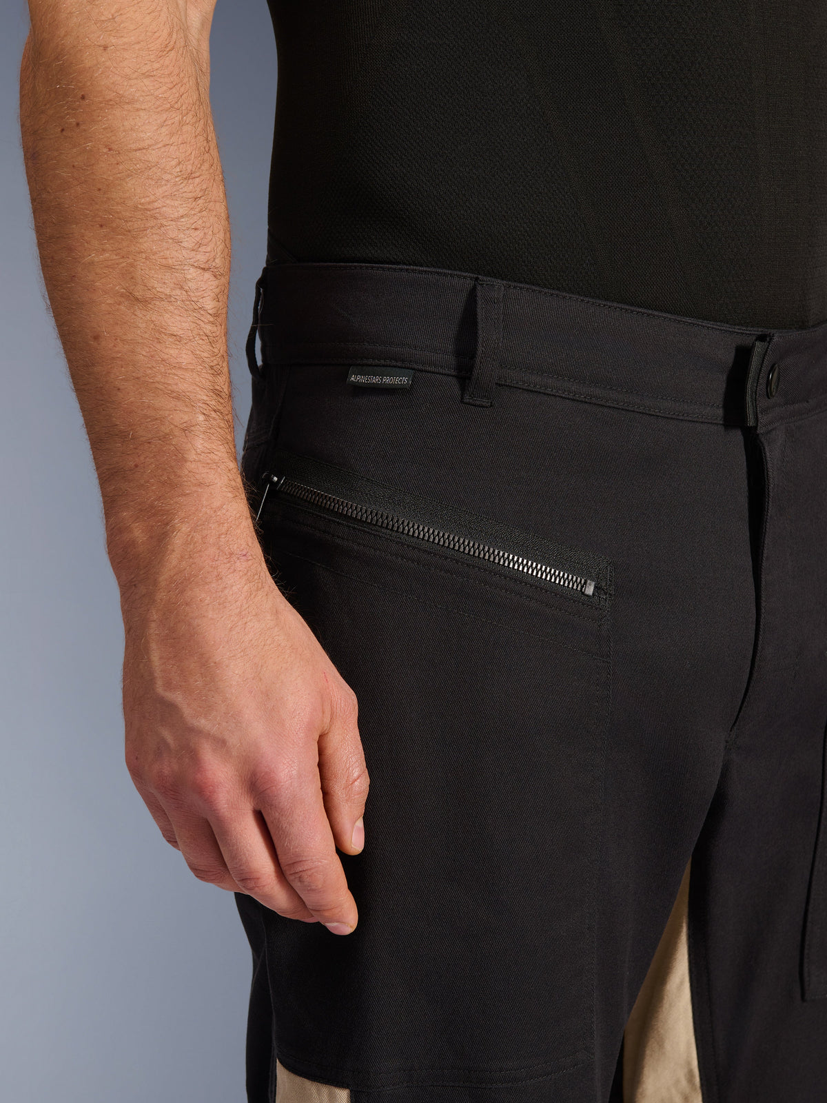 Alpinestars Flex-AST Canvas Pants in Black Aluminum, close-up view of the hip area featuring a horizontal zippered riding pocket, belt loops, and small branding tag, durable stretch polycotton construction for urban riding.