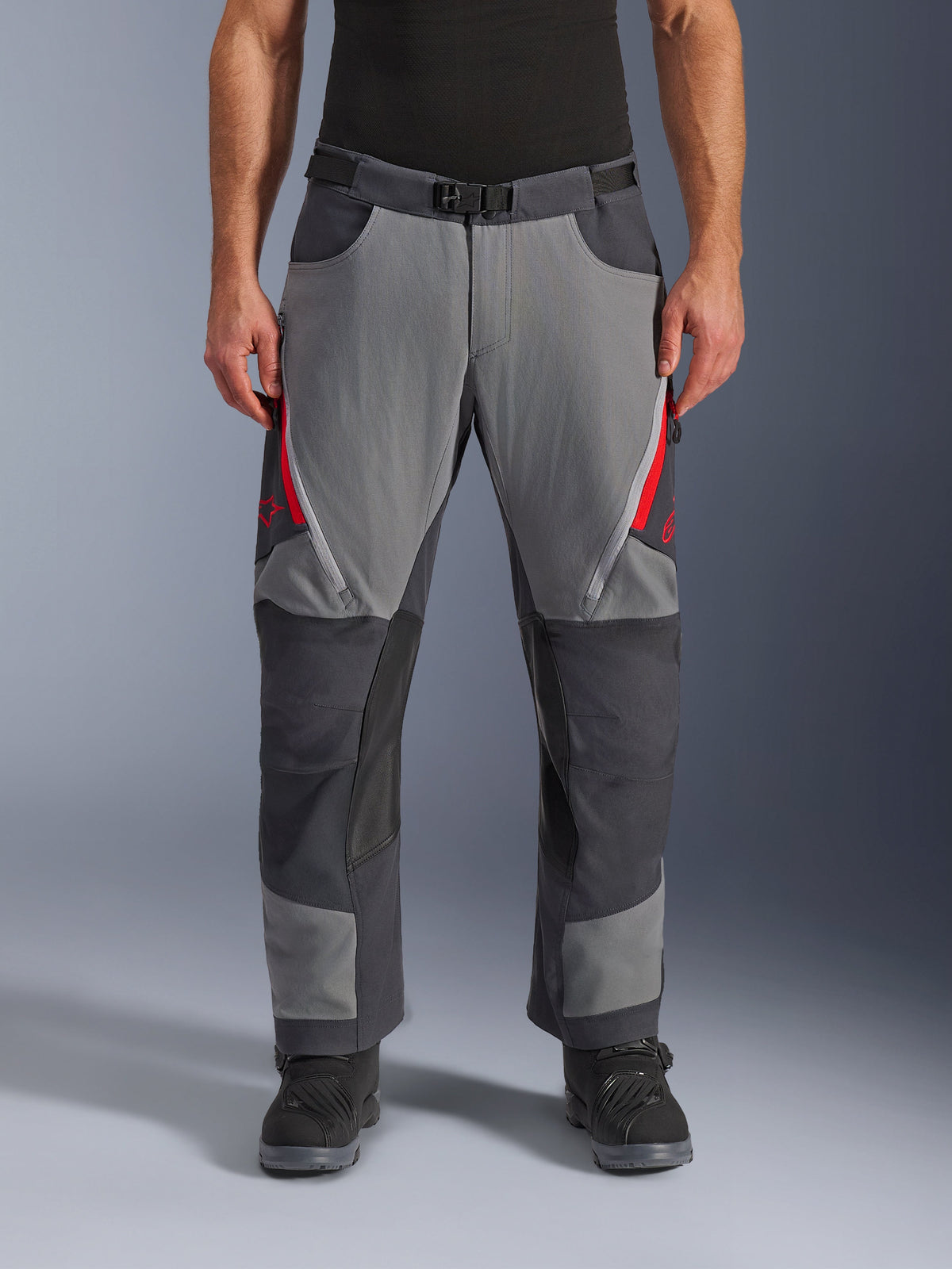 Alpinestars Maxdura Dual Pants, Adventure Motorcycle Pants, Dark Gray and Deep Gray with Red accents, front view showing zippered thigh vents, magnetic buckle belt, and reinforced knee panels, over-boot design for dual-sport riding.