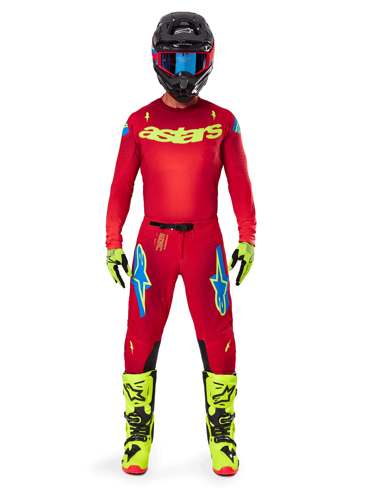 Motocross rider wearing complete racing gear, Red jersey with yellow fluo astars logo, Alpinestars 2025 Supertech Maker Pants in Bright Red and Yellow Fluo, featuring blue logos on thighs, yellow fluo gloves and boots, black helmet with blue goggles, coordinated pro-level motocross outfit