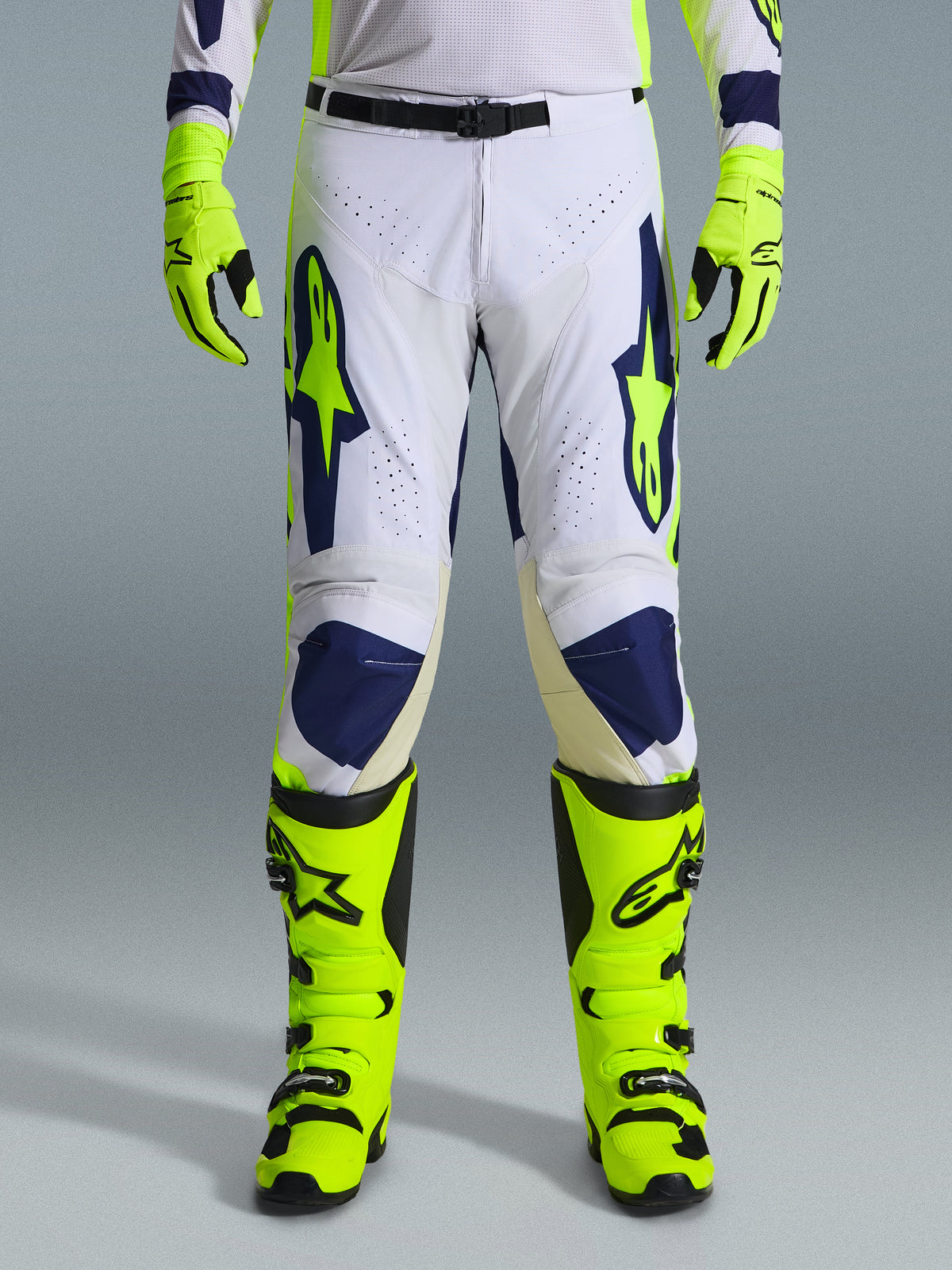 Alpinestars 2026 Racer Air Riway Pants, Motocross Pants, Light Gray Yellow Fluo and Blue, worn with matching neon yellow gloves and boots, featuring perforated front panels for airflow and bold blue and yellow branding, athletic design for off-road performance