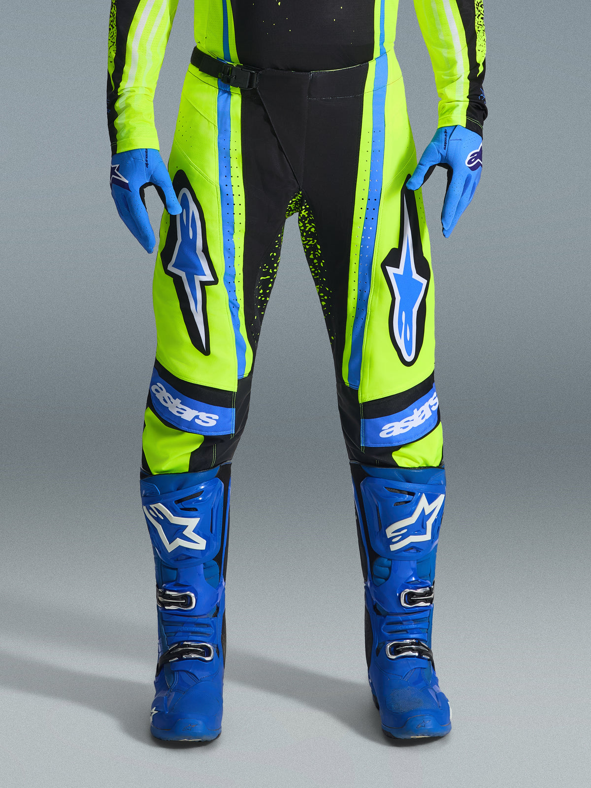 Alpinestars 2026 Techstar Nomur Pants, Motocross Pants, Yellow Fluo and Dark Navy with Blue accents, worn with matching blue gloves and boots, featuring bold Astars logos on the thighs and a performance-engineered design for off-road racing.