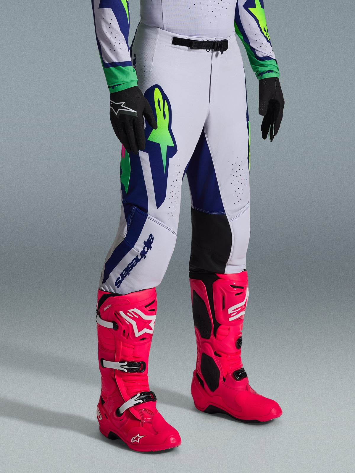 Alpinestars 2026 Supertech Vista Pants, Motocross Pants, Light Gray with Yellow Fluo and Blue accents, worn with vibrant pink motocross boots and black gloves, athletic race fit with durable stretch construction for elite off-road performance