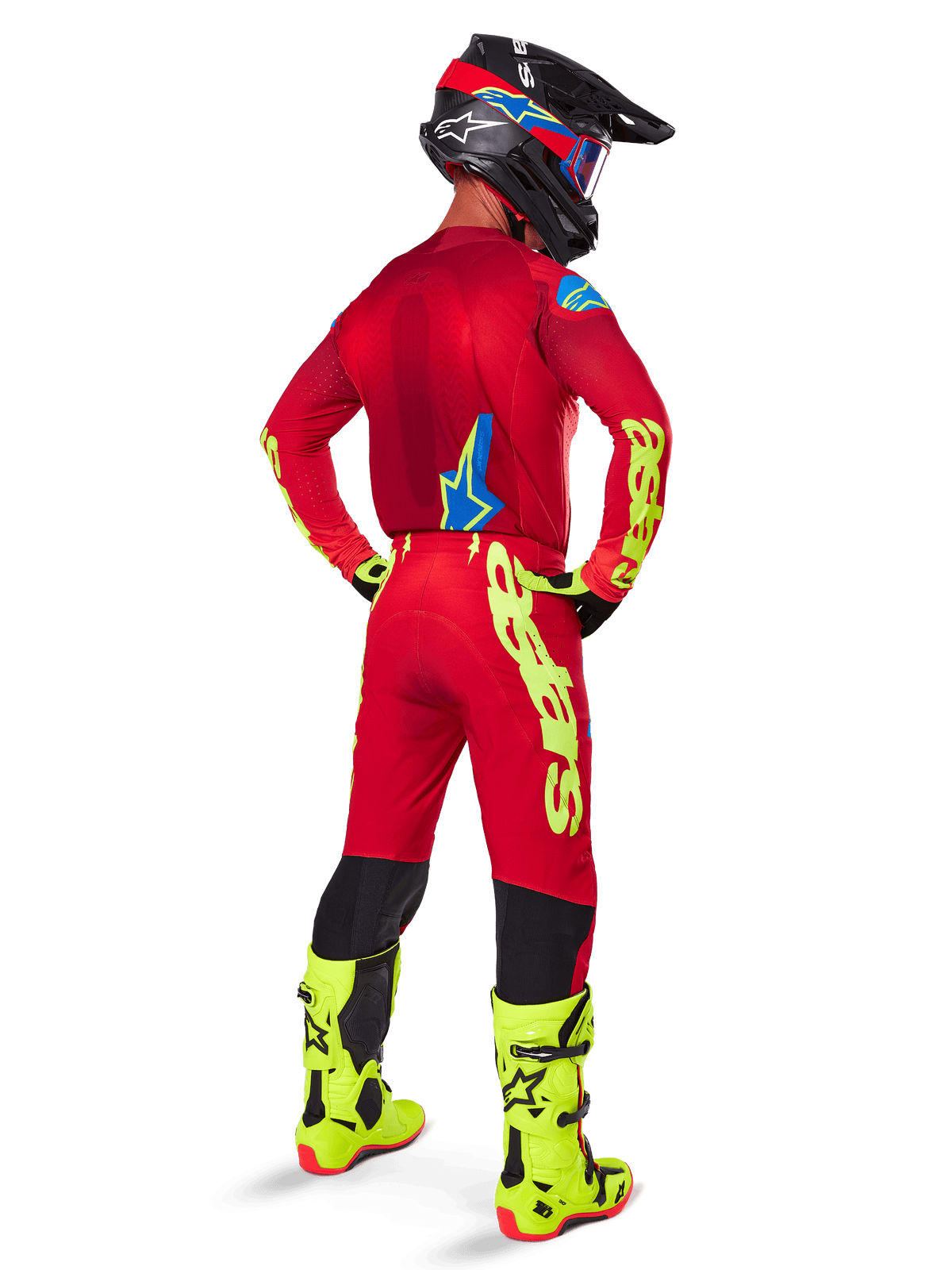 Motocross rider seen from the back wearing the Alpinestars 2025 Supertech Maker Jersey, Bright Red and Yellow Fluo, matching pants with yellow branding, yellow fluo boots, and a black and red helmet, coordinated outfit for pro-level off-road racing