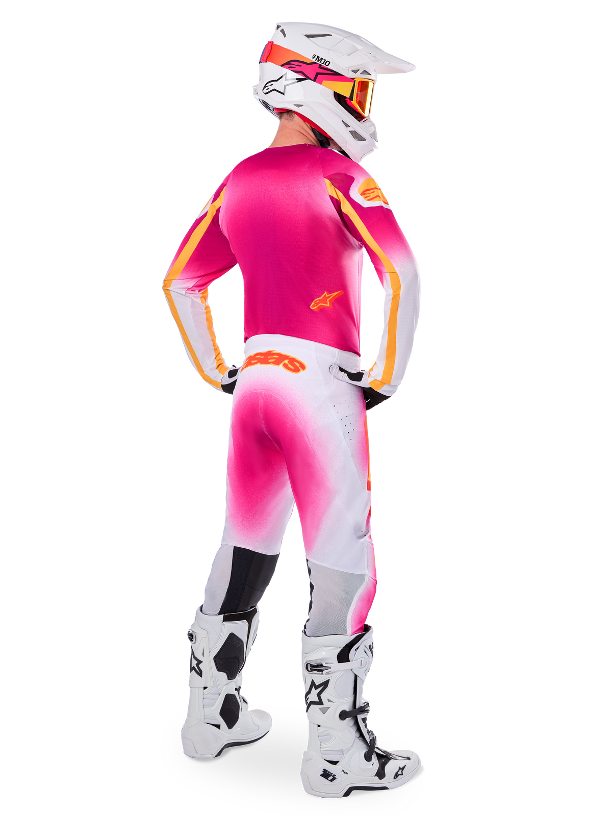 Motocross rider wearing complete racing gear, Pink Fluo and White Limited Edition Supertech AFD MIG Jersey, matching white and pink pants with orange branding, white helmet with pink accents and orange goggles, white and black motocross boots, coordinated outfit for off-road racing