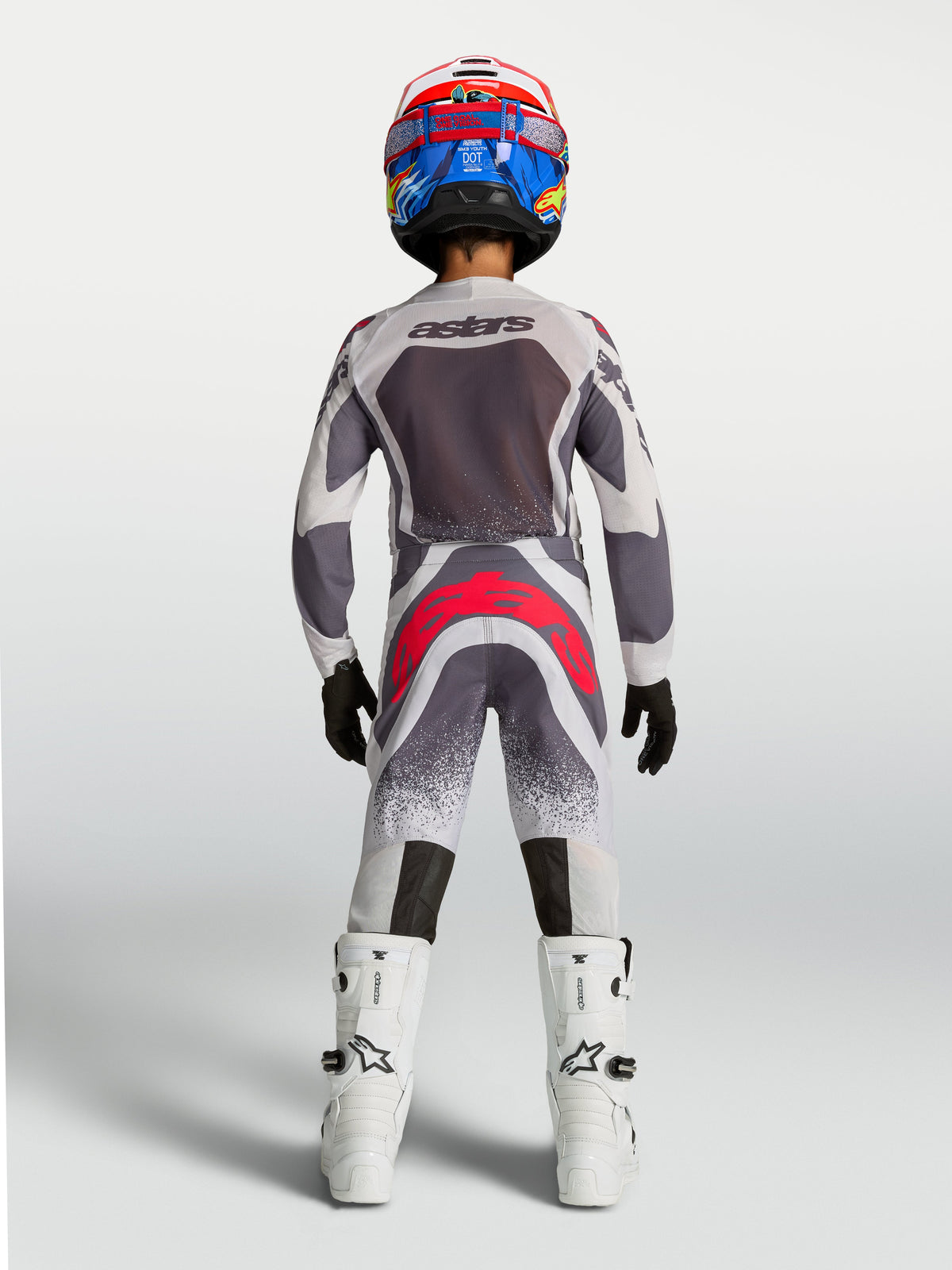 Alpinestars 2027 Youth Supertech Swan Jersey and Gear Set, gray and white motocross gear with red accents, rear view.