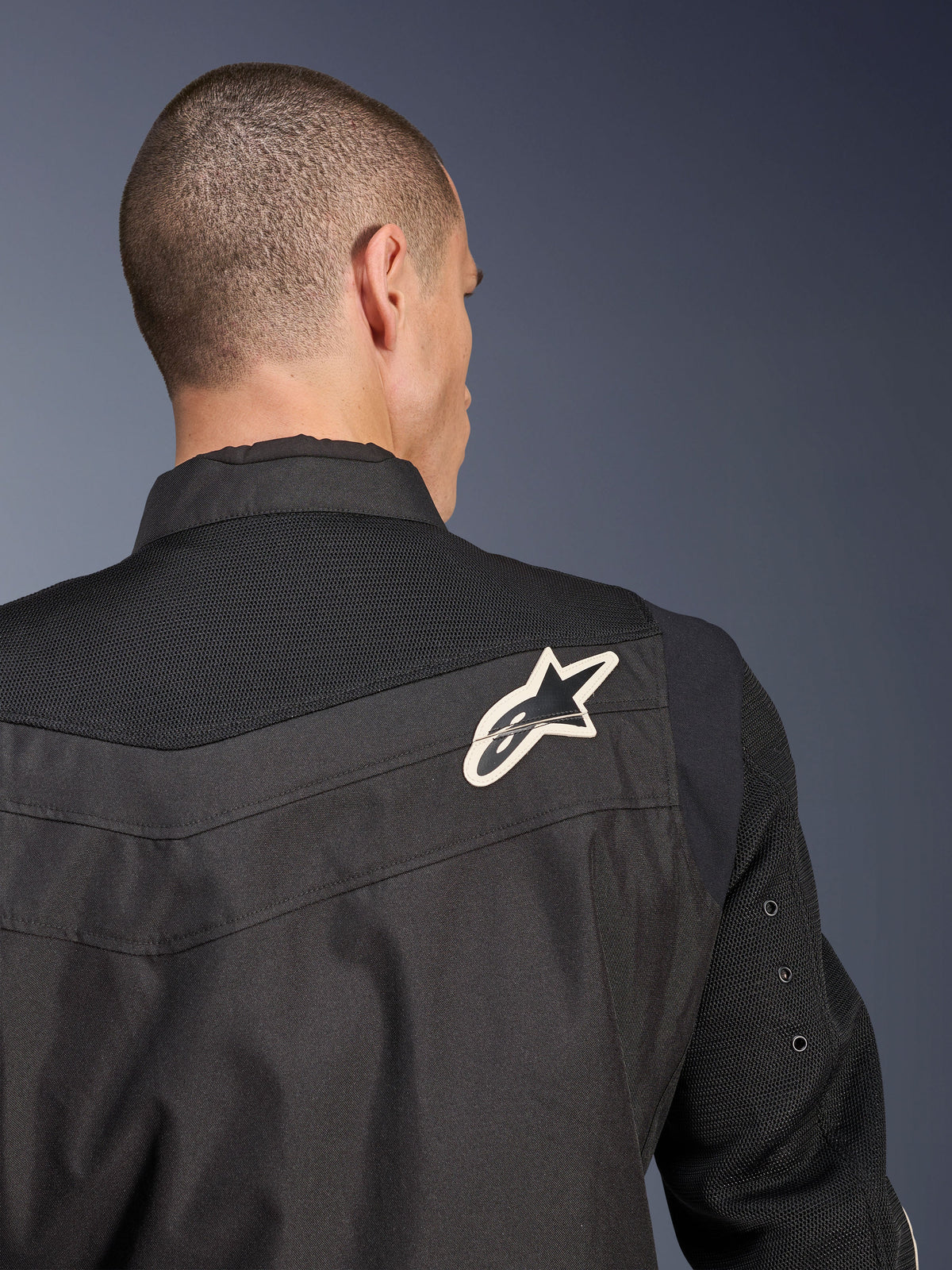 Alpinestars T-Dyno Air Jacket, Black textile motorcycle jacket, close-up back view highlighting the breathable 3D mesh yoke and sleeves, featuring a white and black star logo on the right shoulder.