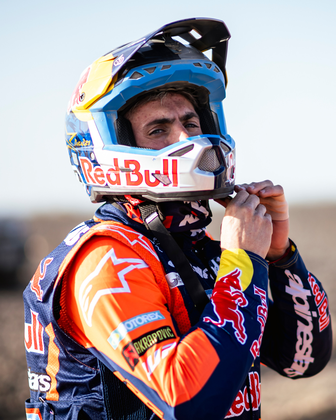 Kevin Benavides wearing a Red Bull helmet and enduro Alpinestars jacket in an outdoor setting