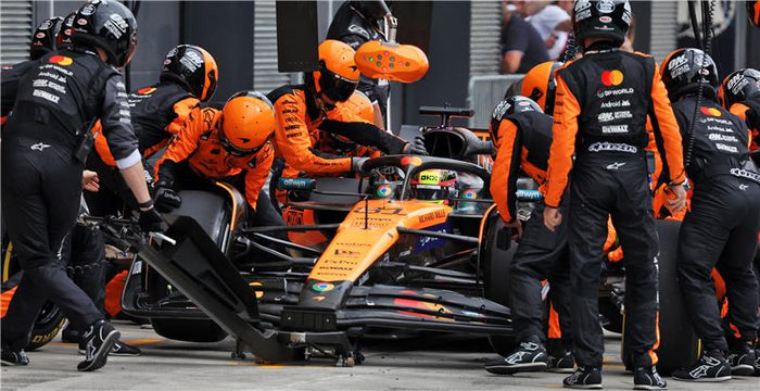 Full Lando Norris crew in the pit changing tires