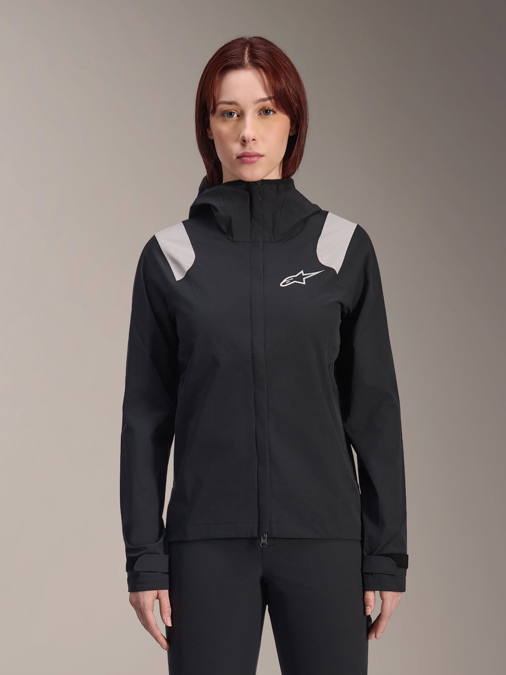 Alpinestars Stella A-Dura Rain Jacket, Women's Cycling Rain Jacket, Black with light gray shoulder panels, hooded technical shell with white logo on chest, adjustable Velcro cuffs, professional gear for MTB and wet weather riding