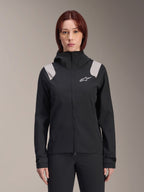 Alpinestars Stella A-Dura Rain Jacket, Women's Cycling Rain Jacket, Black with light gray shoulder panels, hooded technical shell with white logo on chest, adjustable Velcro cuffs, professional gear for MTB and wet weather riding