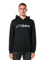 Alpinestars Blaze V3 Hoodie, black with white logo, casual streetwear, featuring front kangaroo pocket and drawstring hood, worn by a man, modern motorsport-inspired design
