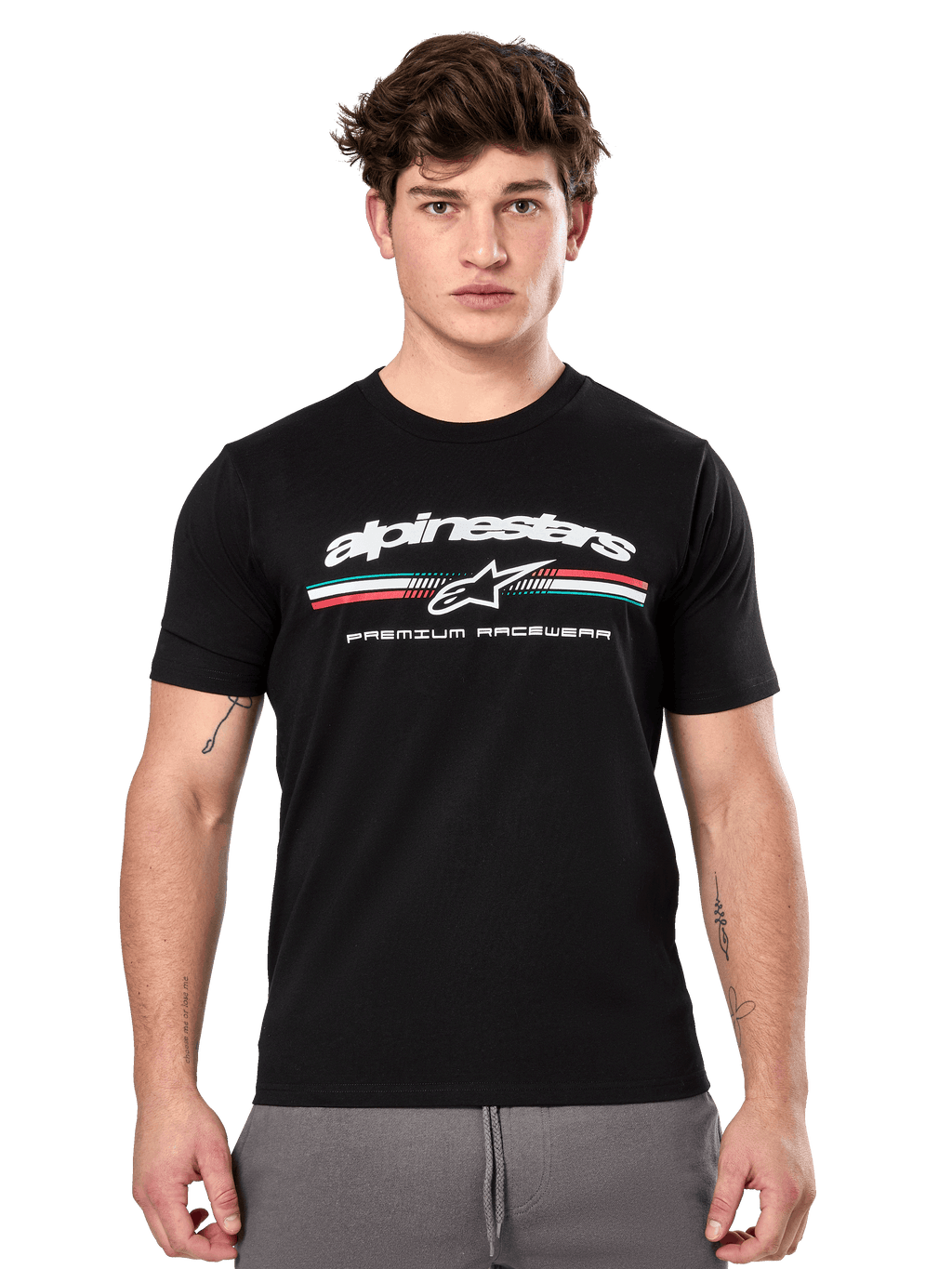 Alpinestars Prevail CSF Tee, Black Short Sleeve T-Shirt worn by a model, featuring white branding with a tri-color stripe and "PREMIUM RACEWEAR" graphic, casual motorsport streetwear